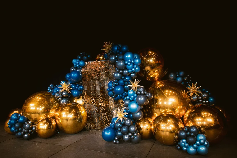 Navy, gold and metallic starburst balloons arranged as an event backdrop