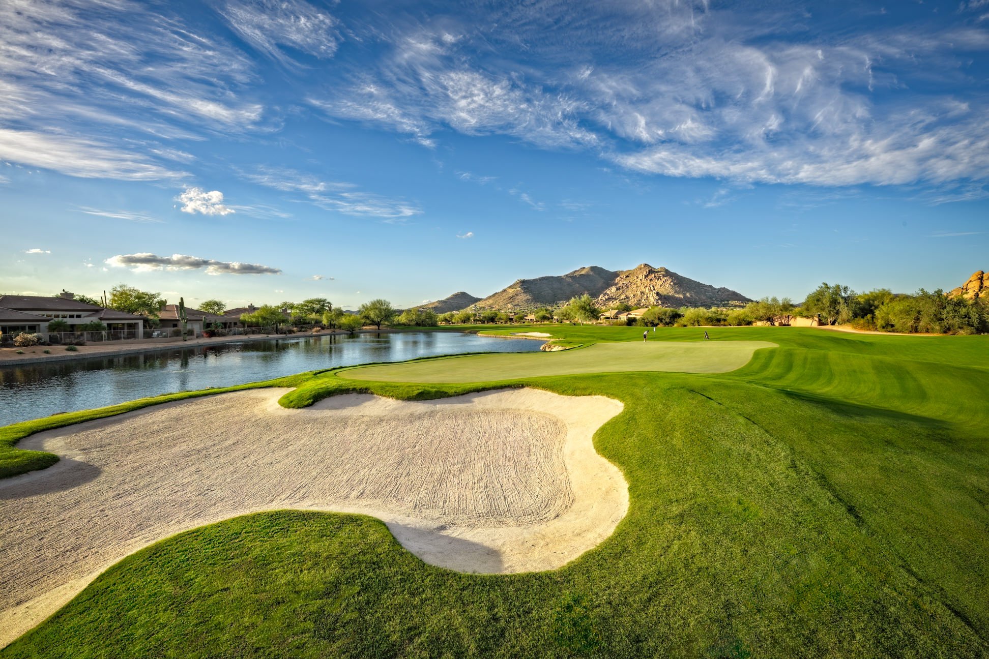 Golf course at Terravita Golf & Country Club in North Scottsdale, featuring a green, white-sand bunkers and surrounding desert mountains.