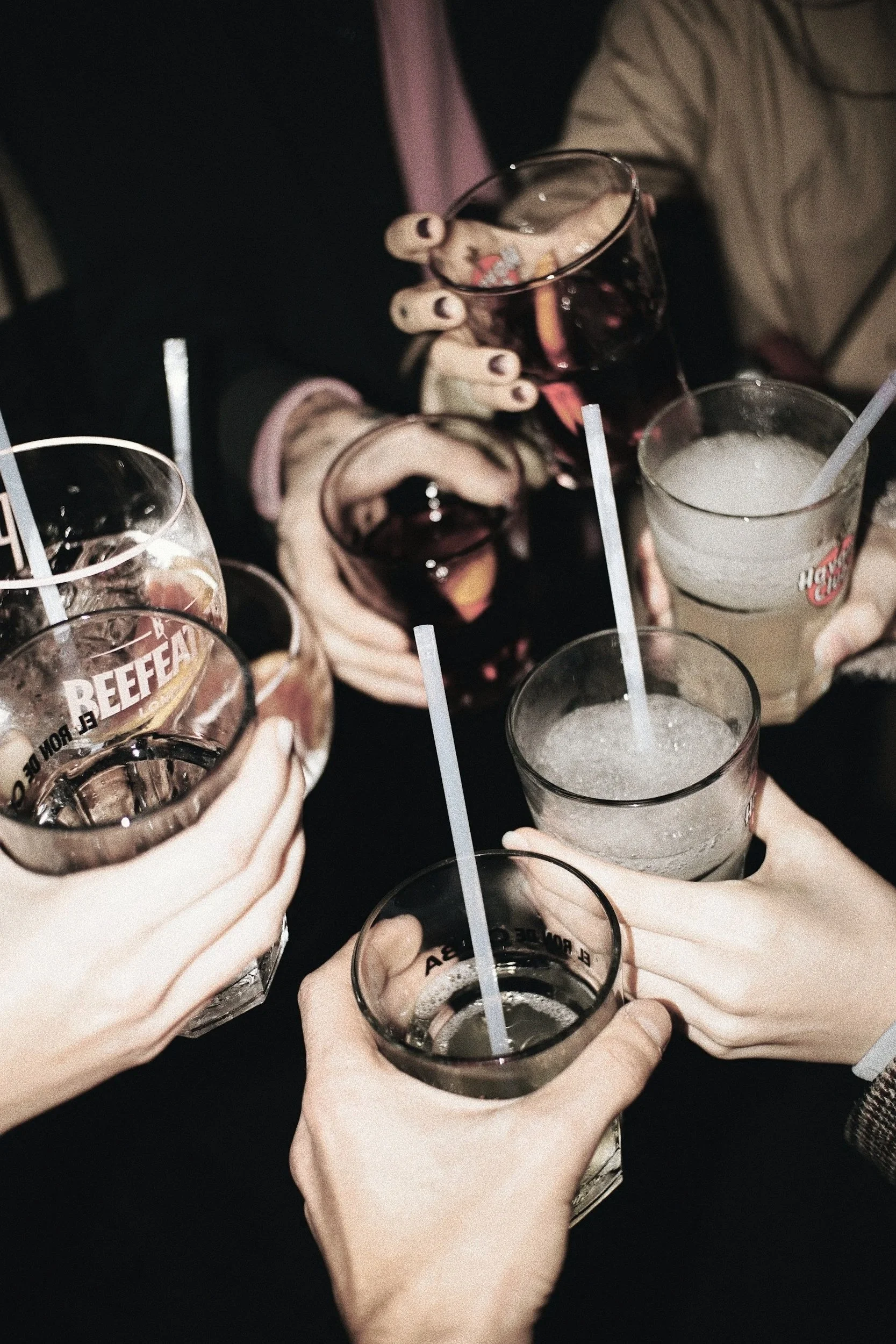 Diverse persone con in mano bicchieri di bevande per fare un brindisi e festeggiare un'occasione insieme.