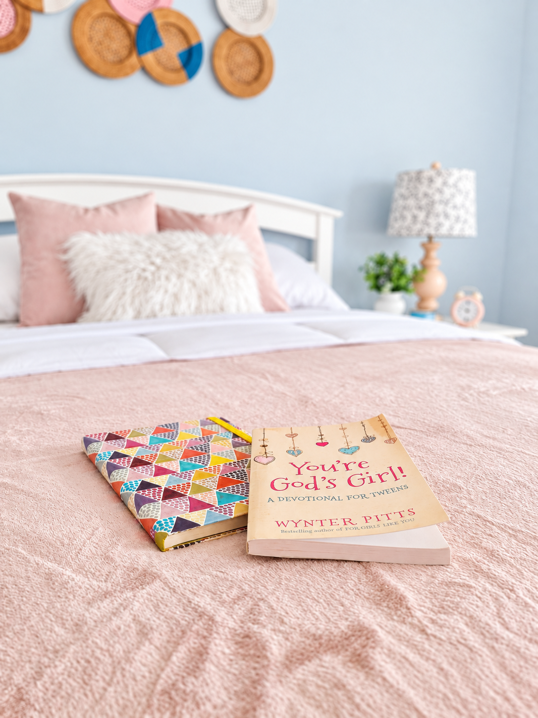 Books styled on a blush bedspread