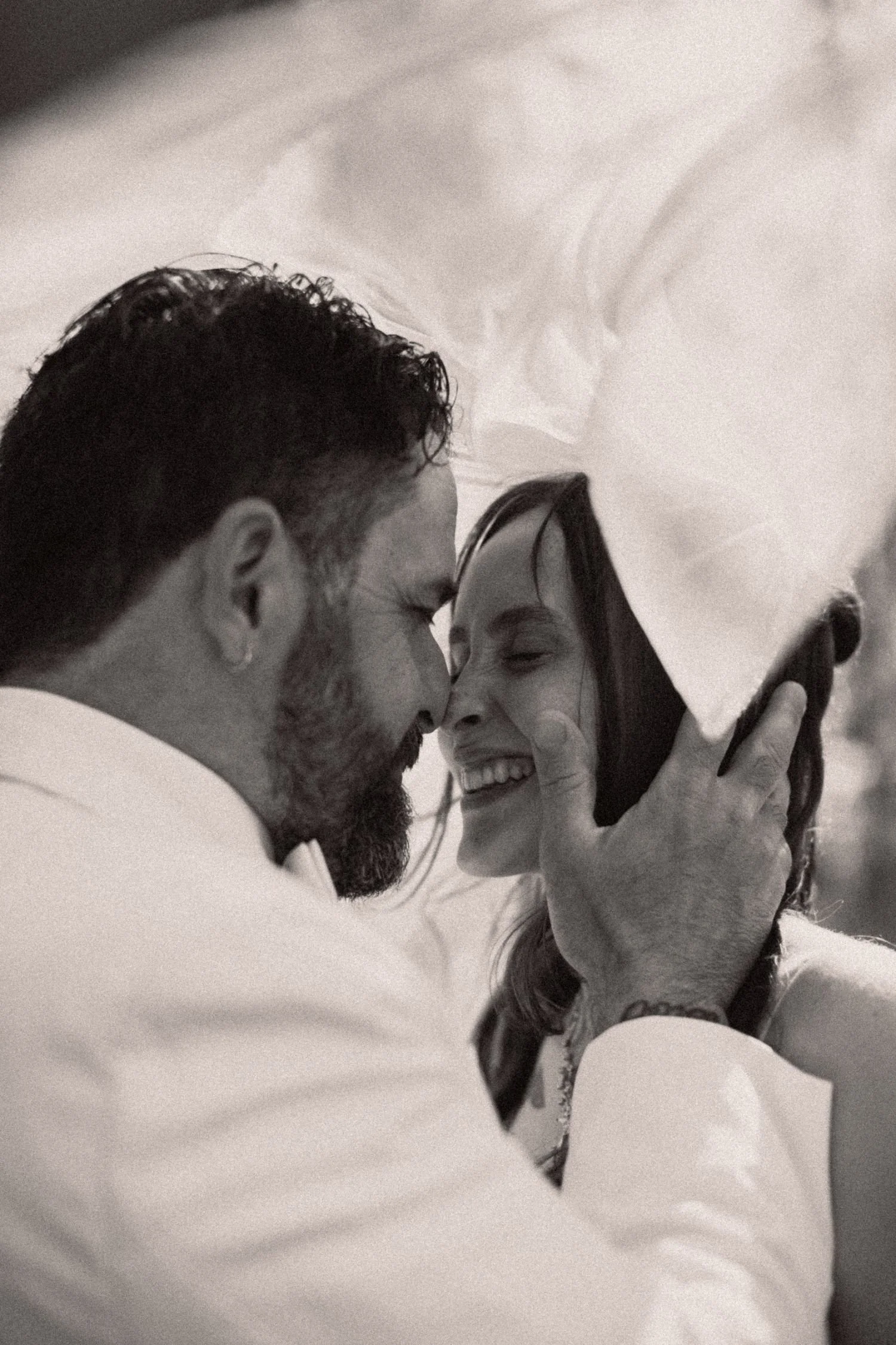 A man and woman close together, about to kiss, with a smartphone being used to capture the moment.