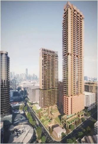 Two high-rise buildings under construction in an urban area with a city skyline in the background