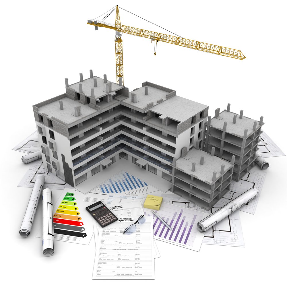 Model of a multi-story building under construction with a construction crane above, surrounded by architectural plans, documents, a calculator, glasses, and rolled-up blueprints.