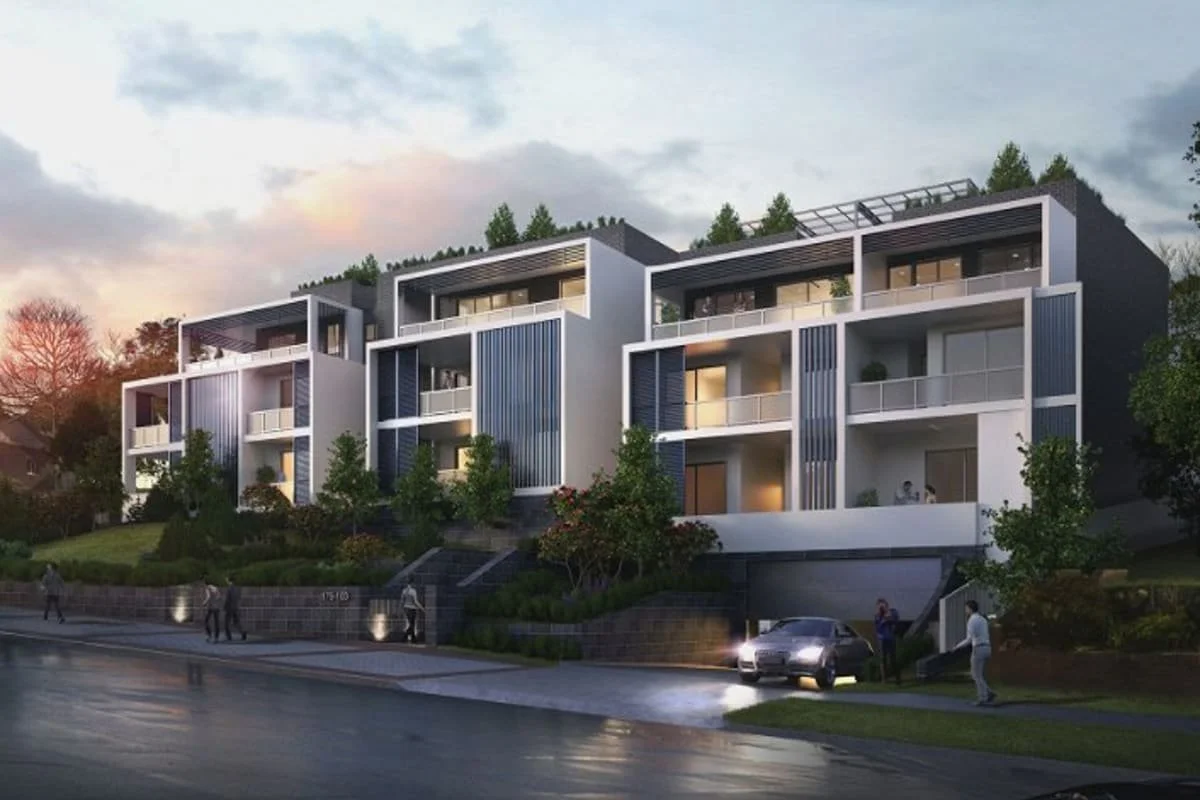 Modern multi-story residential building at dusk with balconies and large windows, surrounded by trees, with pedestrians and cars on the street.