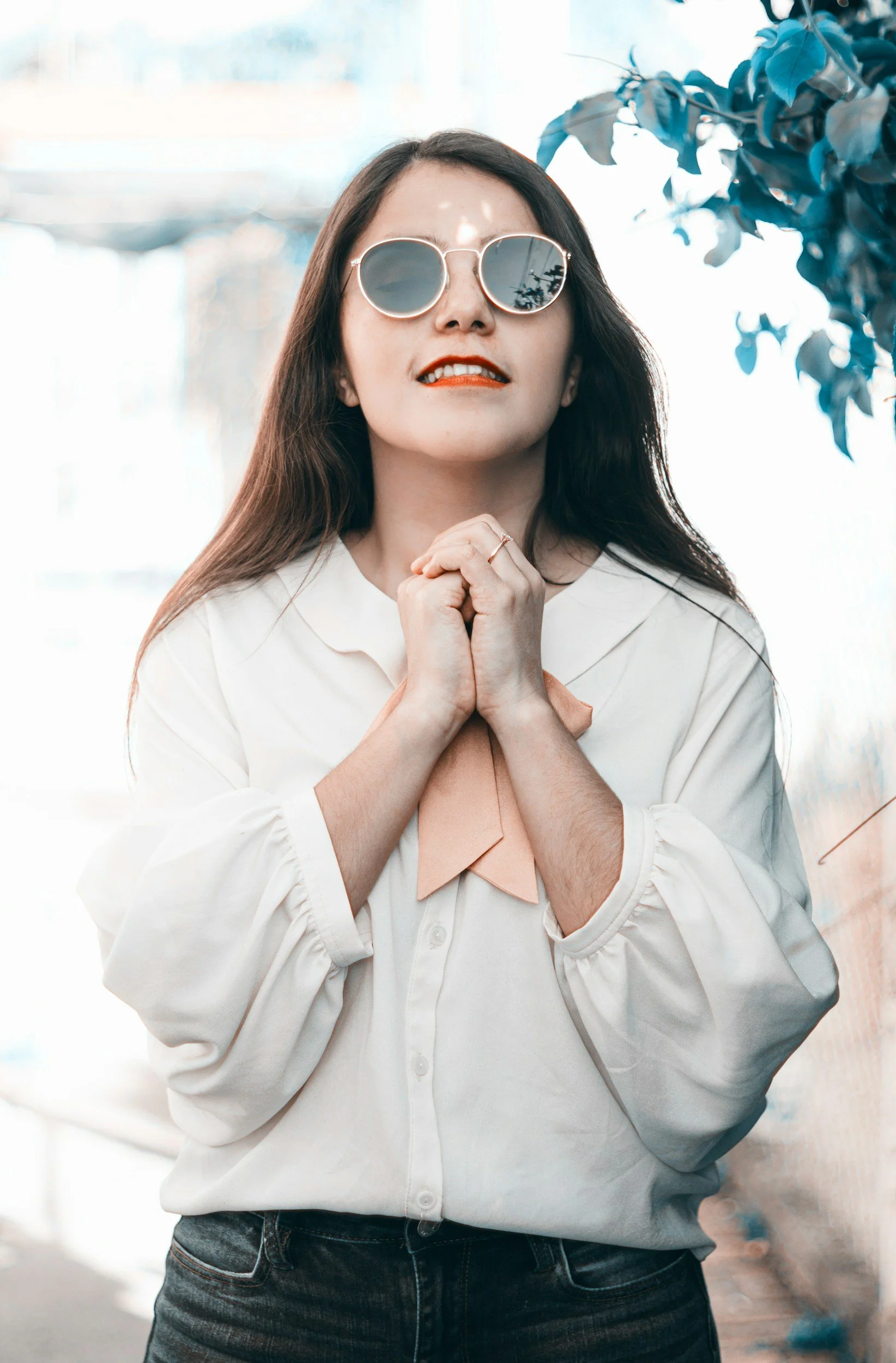 Woman in a white sweater standing outdoors near a tree, representing self-reflection, emotional healing, and personal growth through life's changes and learning how to live without so much anxiety and overwhelm.