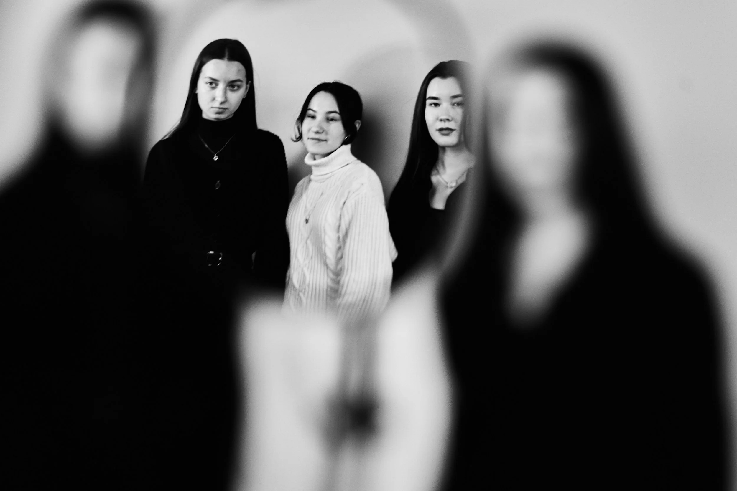 Women standing together in artistic black-and-white portrait, representing identify, belonging, and the complexities of relationships and personal growth. Women are connected through shared experience of anxiety and perfectionism.