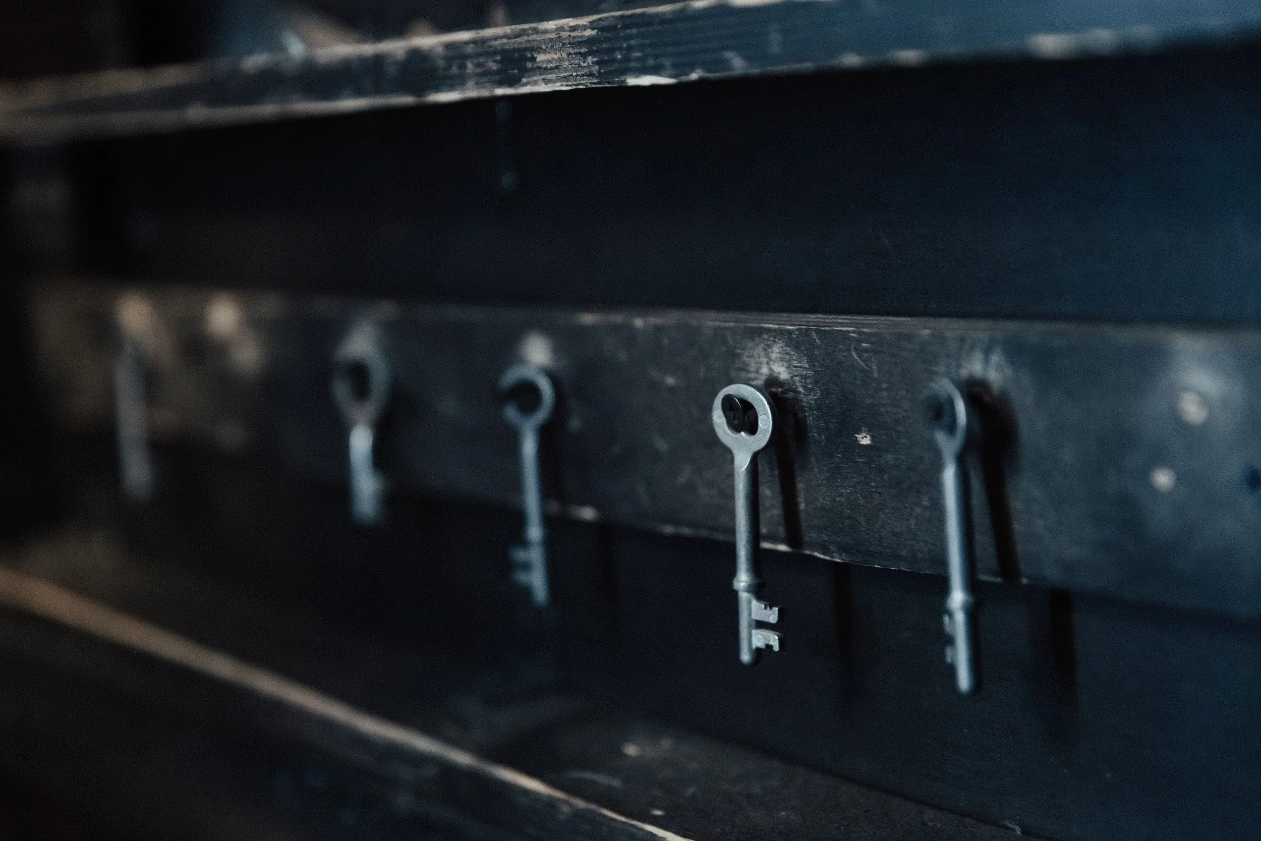 Close-up of a mechanical or electronic device with small metal components and screws, with a dark background.