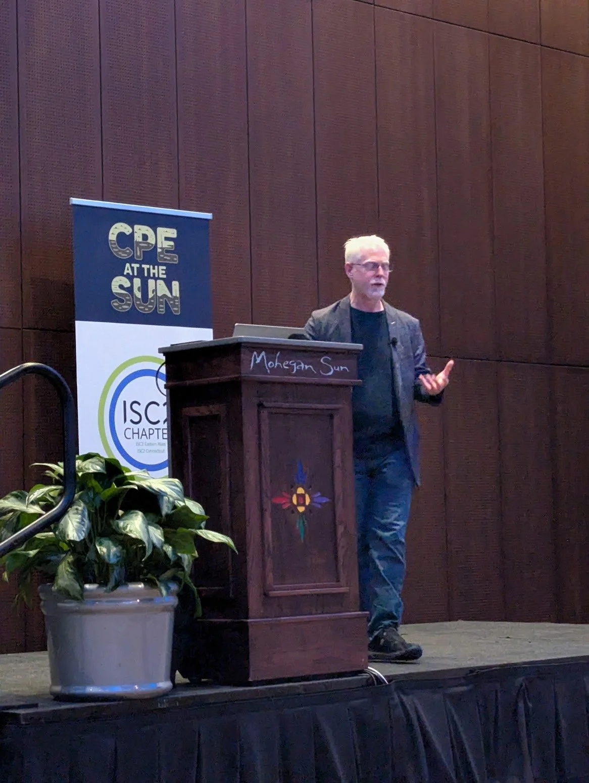 Perry Carpenter on a stage at Mohegan Sun, presenting at the 'CPE At The Sun' ISC2 event.