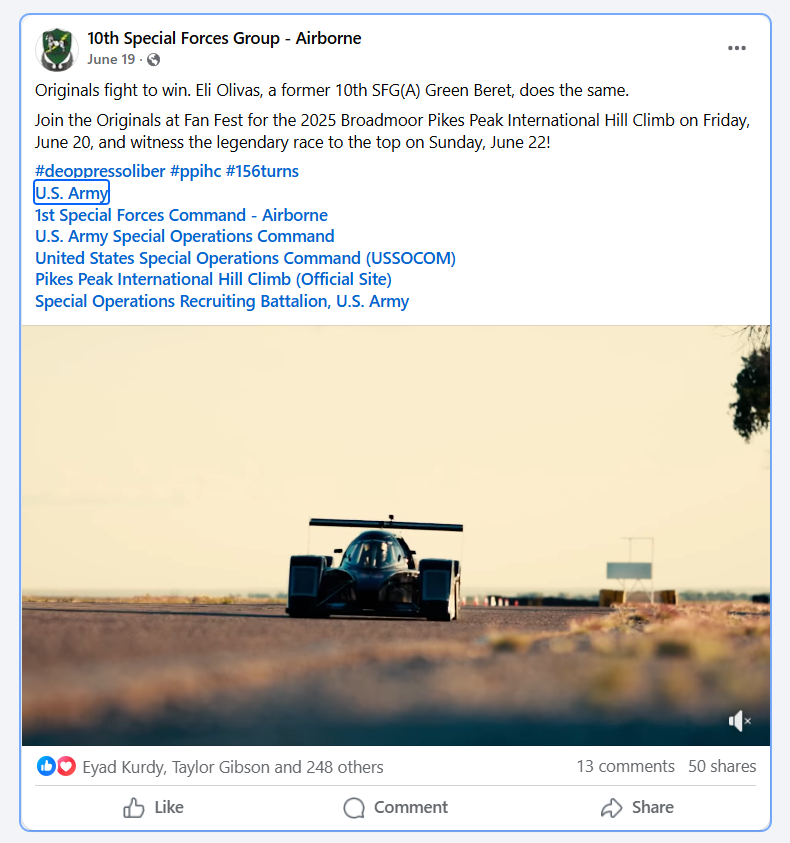 Photo of a black race car on a flat road in a desert landscape with a clear sky.