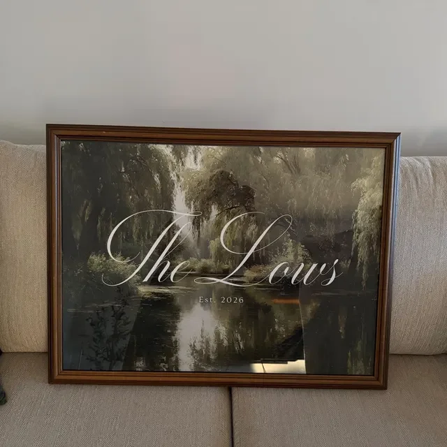 Framed wedding welcome sign with a moody, romantic nature scene of trees and water, with the text 'The Lows' and 'Est. 2026' overlayed. Handmade by January Swift Studio.