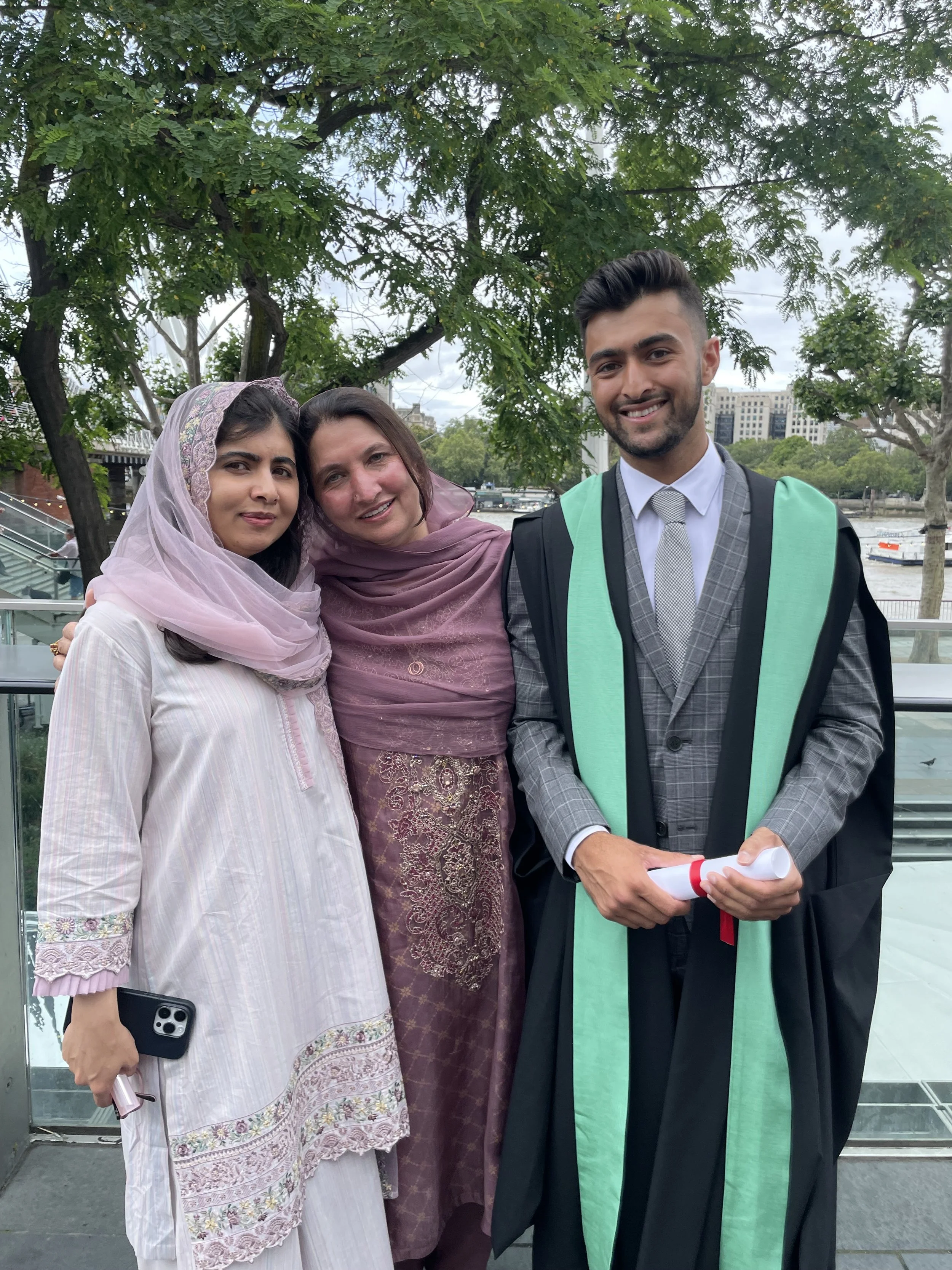 Khushal in his graduation gown with family after graduating from King's College London