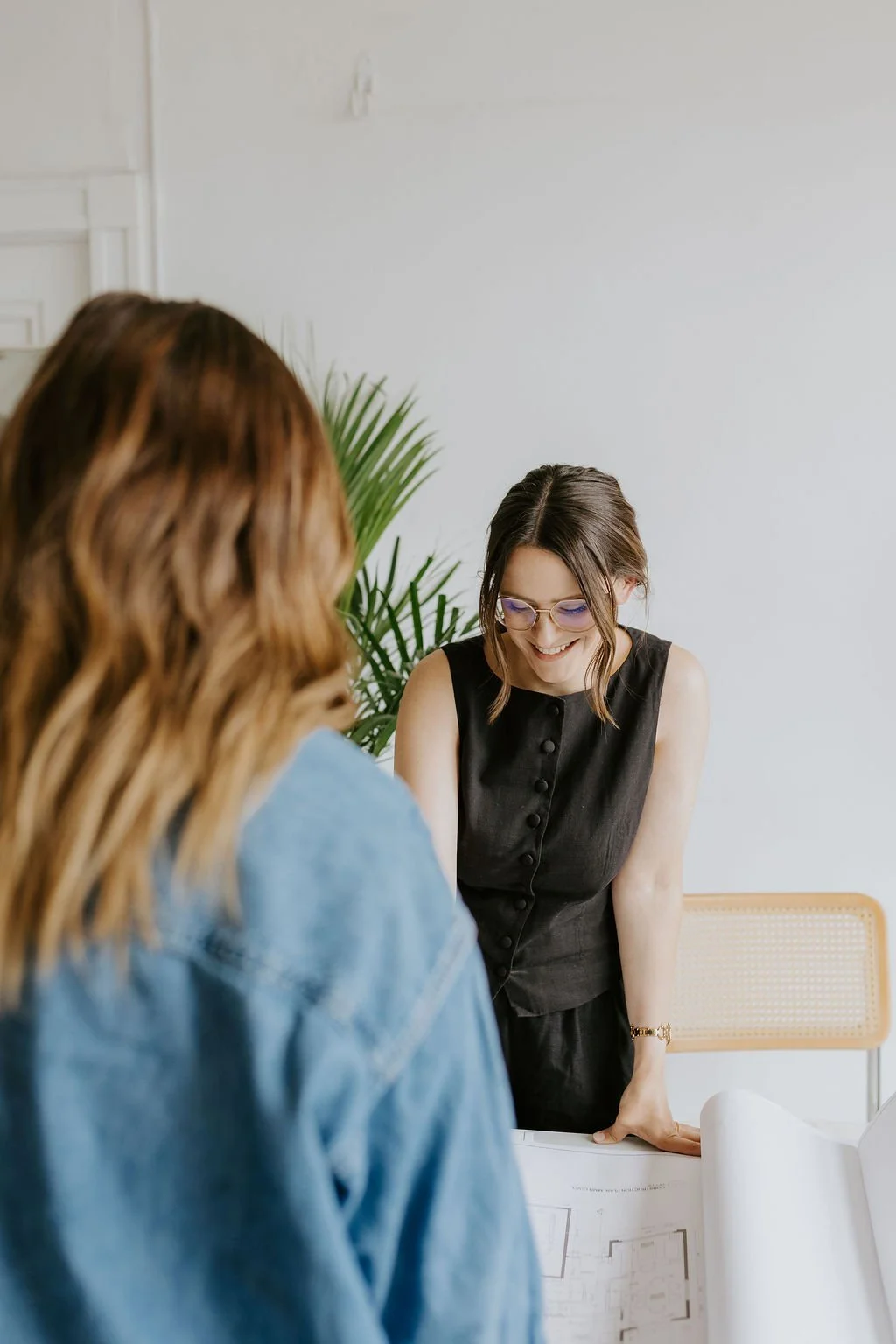 Alaina Gordon reviewing interior design plans with a client during a Vancouver design consultation.