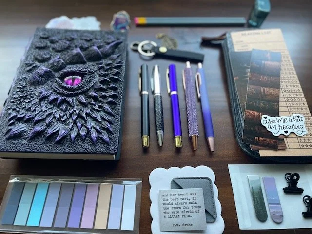 Included a "Bookwyrm" pin and one of the pens had "scales". Kept the theme purple and dark so she could lose herself in her journal.
