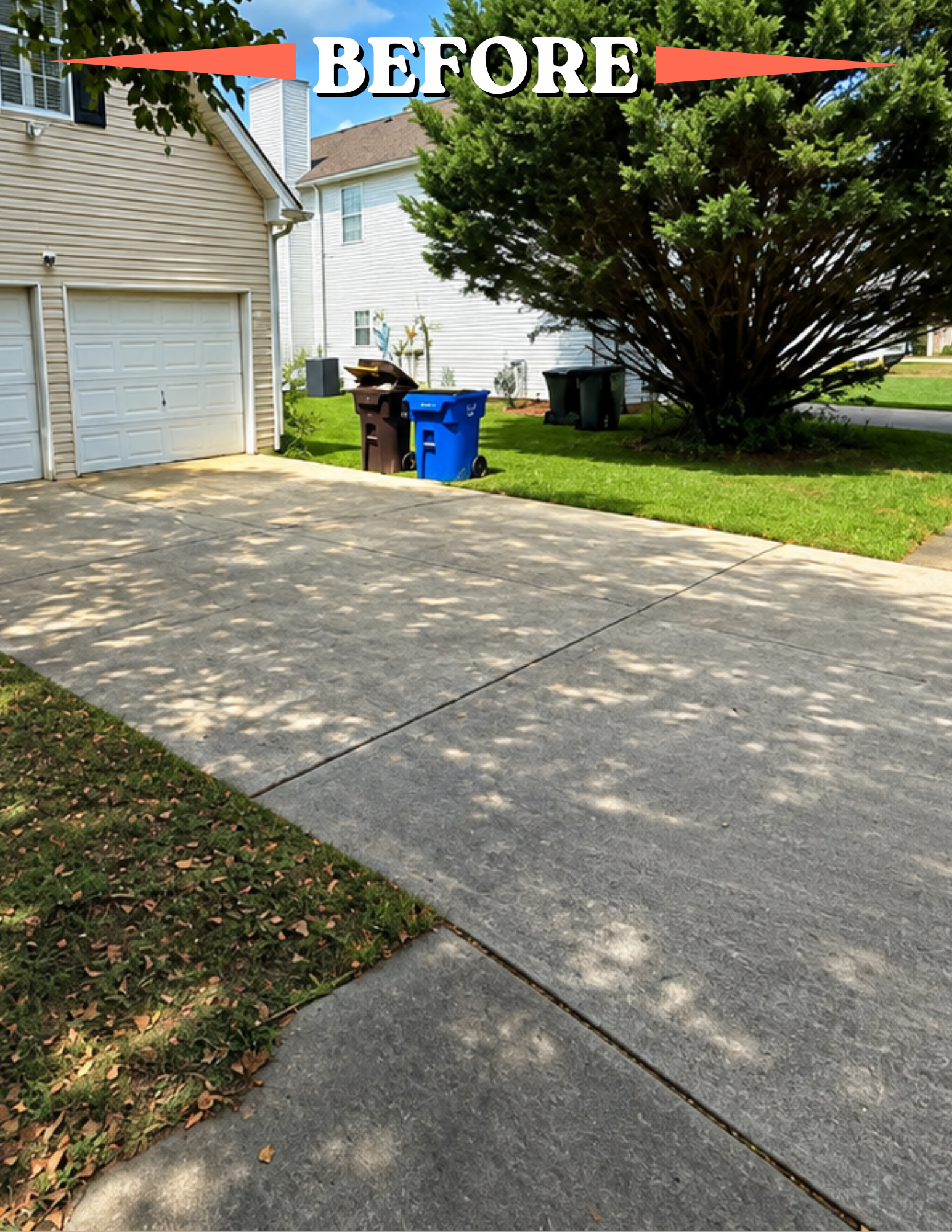A residential driveway bordered by grass and a large tree with shadows cast on the concrete. Trash bins are near the house garage. The house is beige and white, with windows and siding, under a partly cloudy sky.