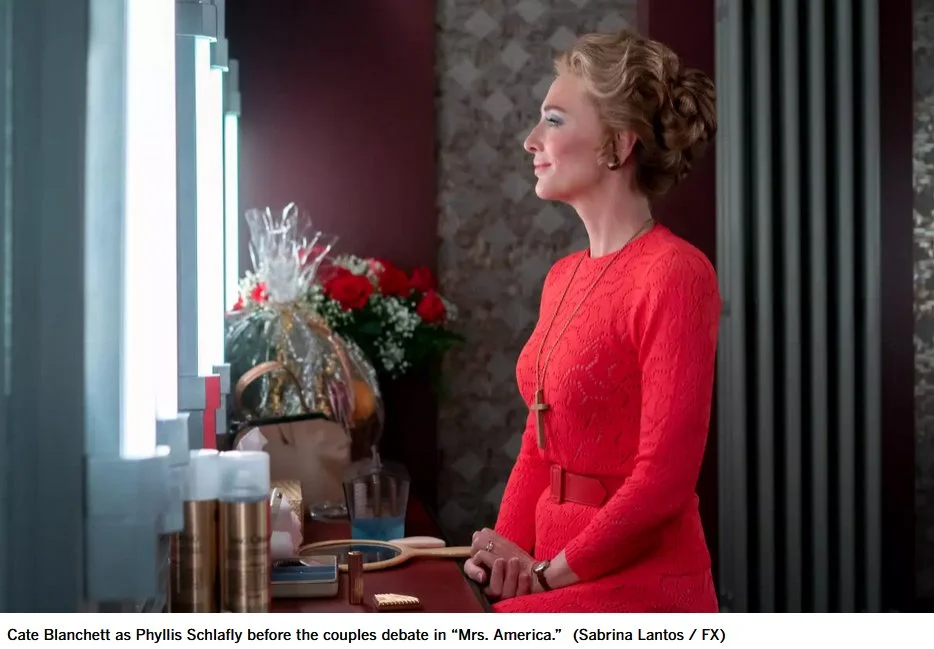 Cate Blanchett as Phyllis Schlafly looking into a mirror in a dressing room.