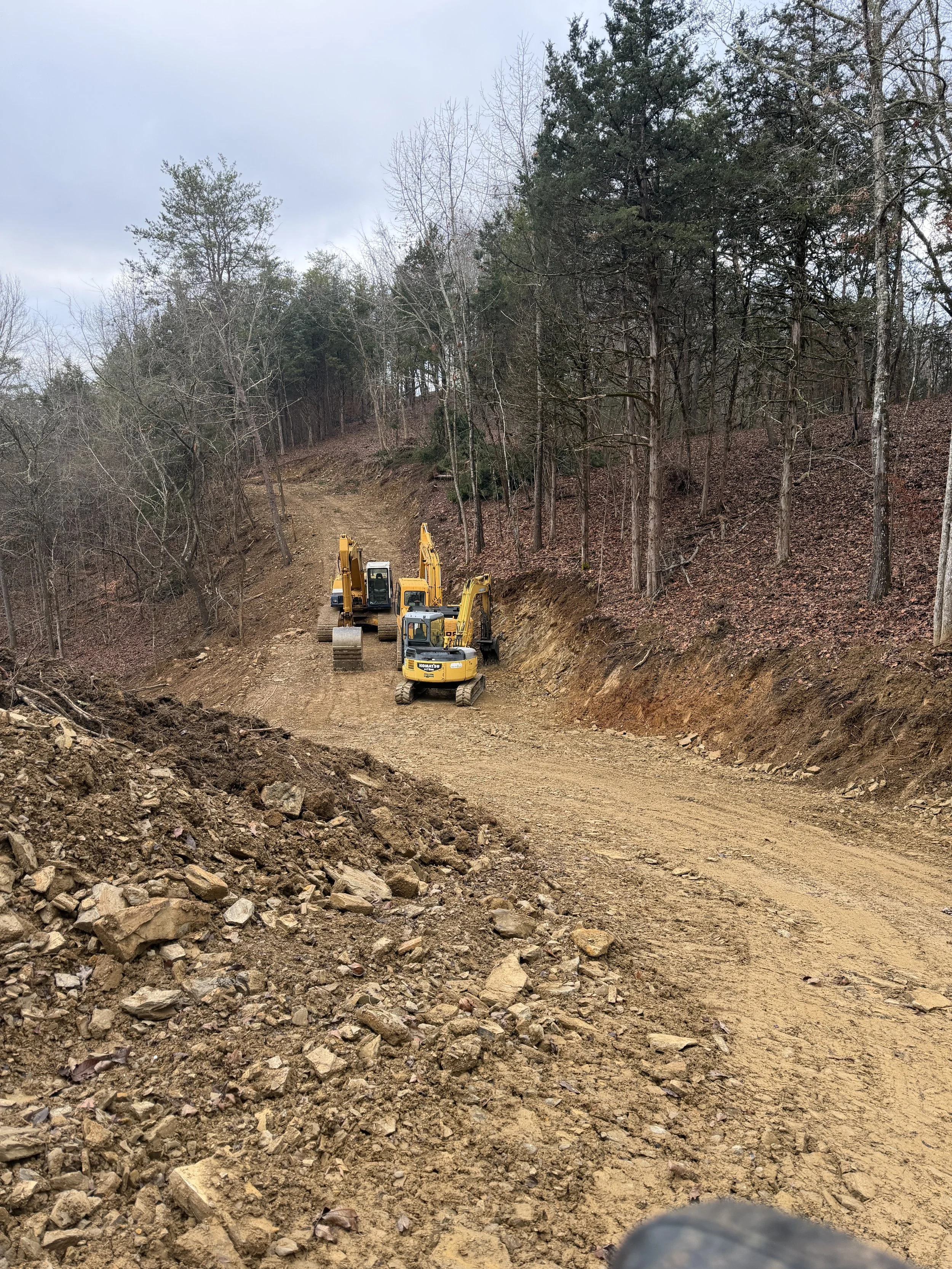 Excavators building a new road through a wooded East Tennessee hillside.