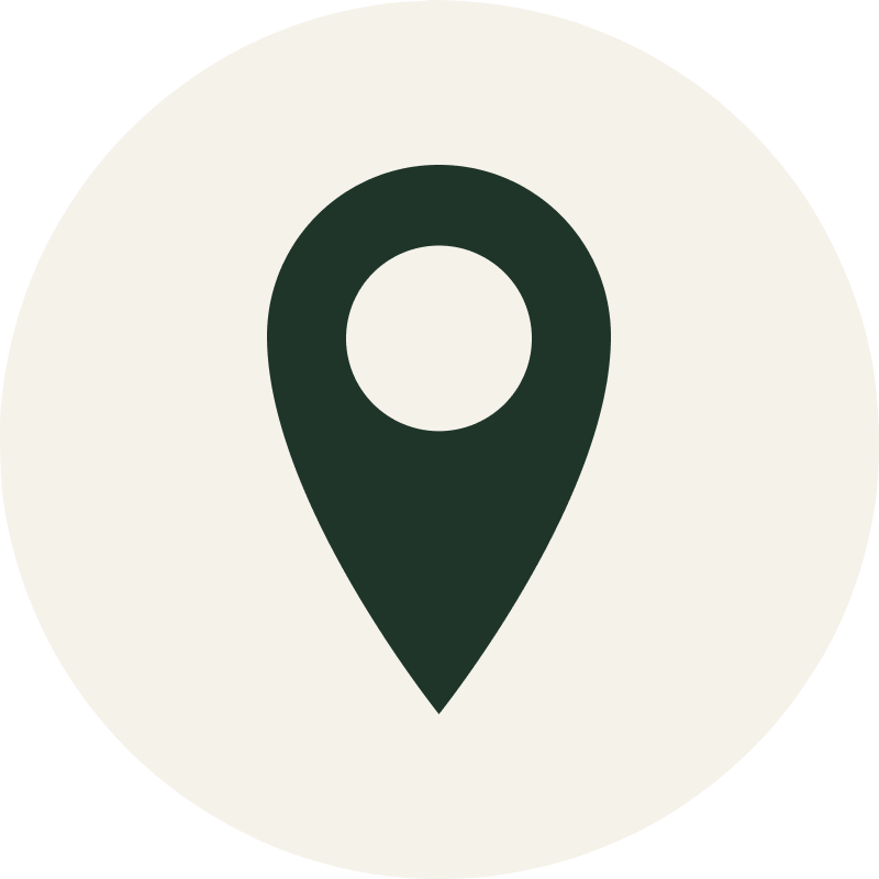 Map location icon with a black map pin inside a white circular background.
