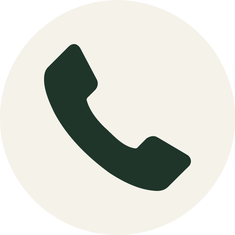 Icon of a black telephone handset on a white circular background.