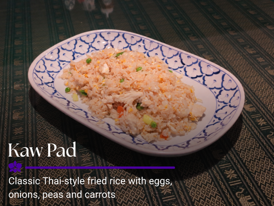 Classic Thai-style fried rice with eggs, onions, peas, and carrots served on a blue and white patterned plate.