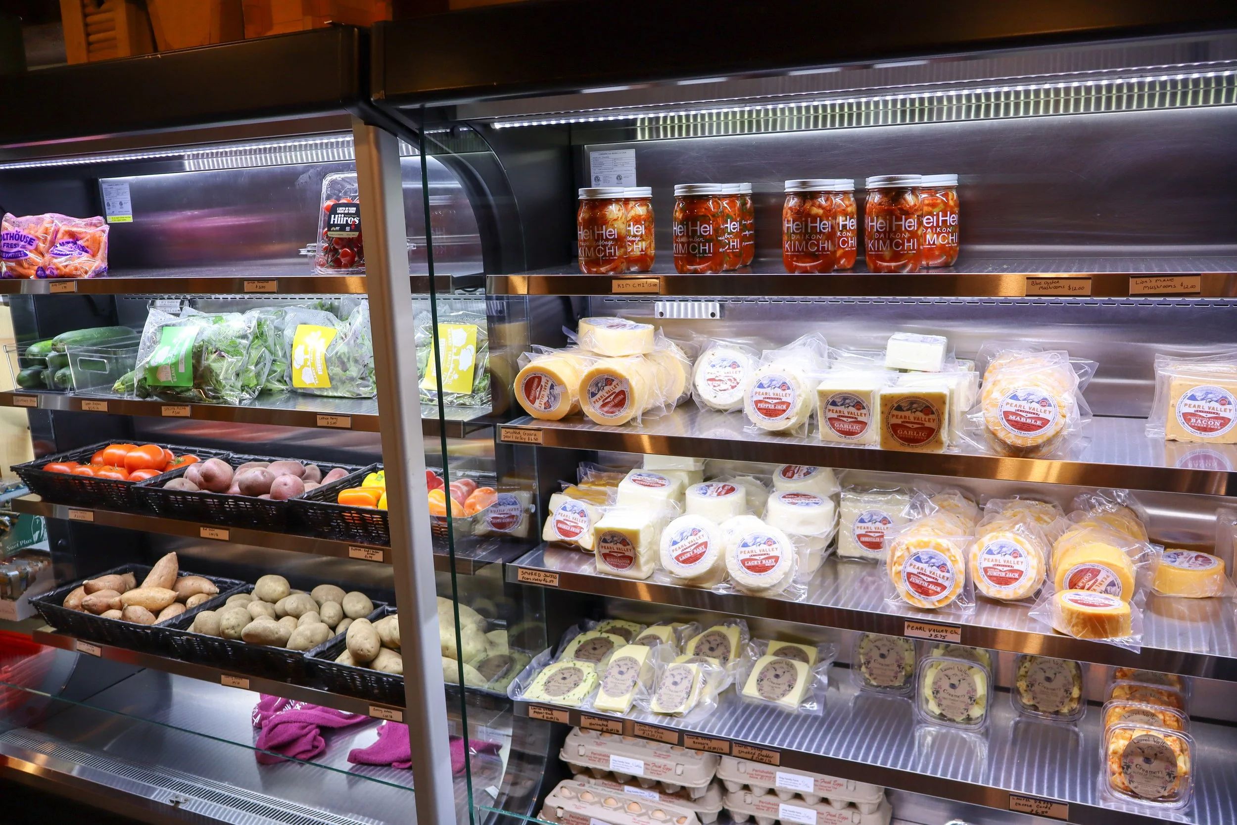 display case with a variety of cheese products and eggs