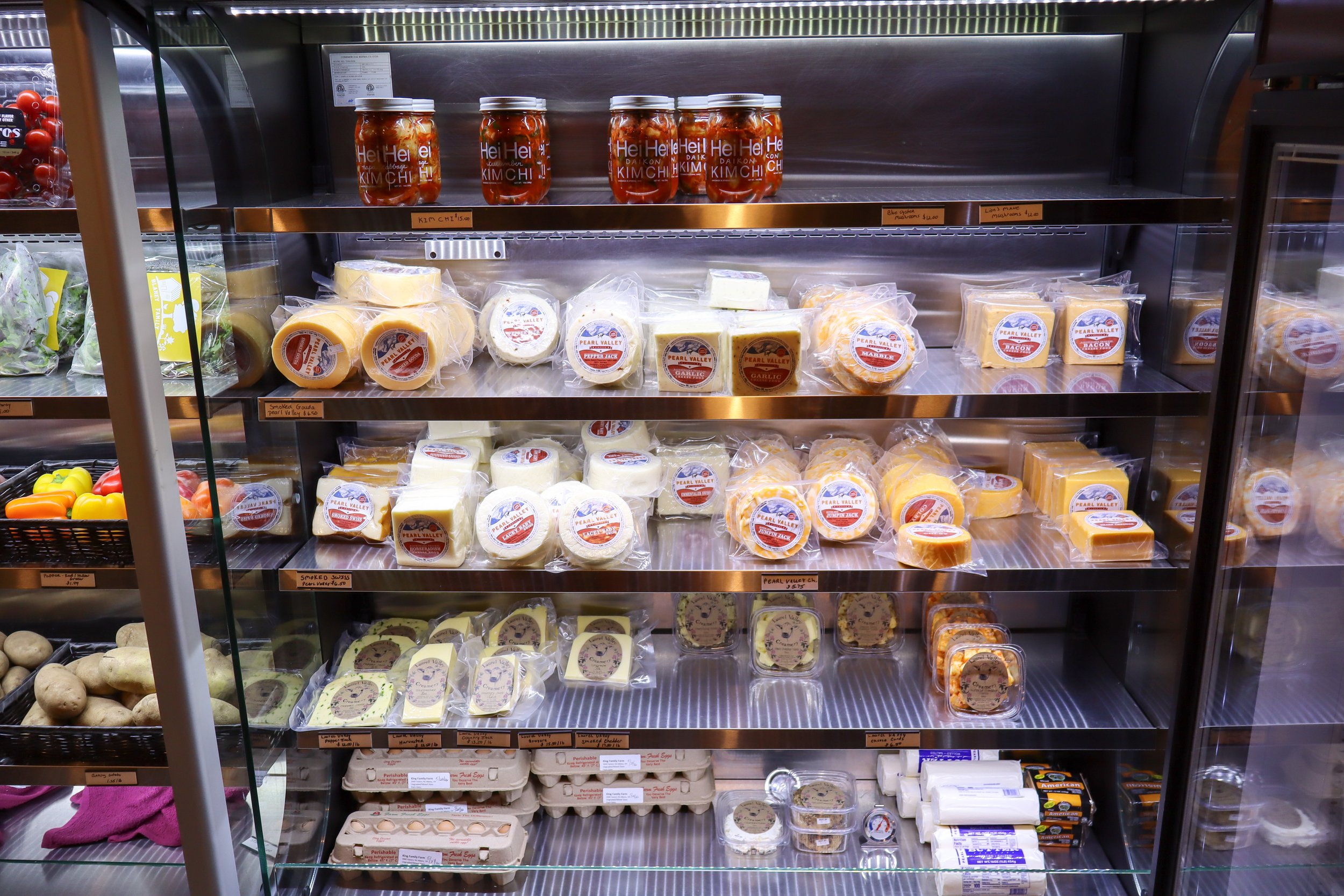 display case with a variety of cheese products and eggs