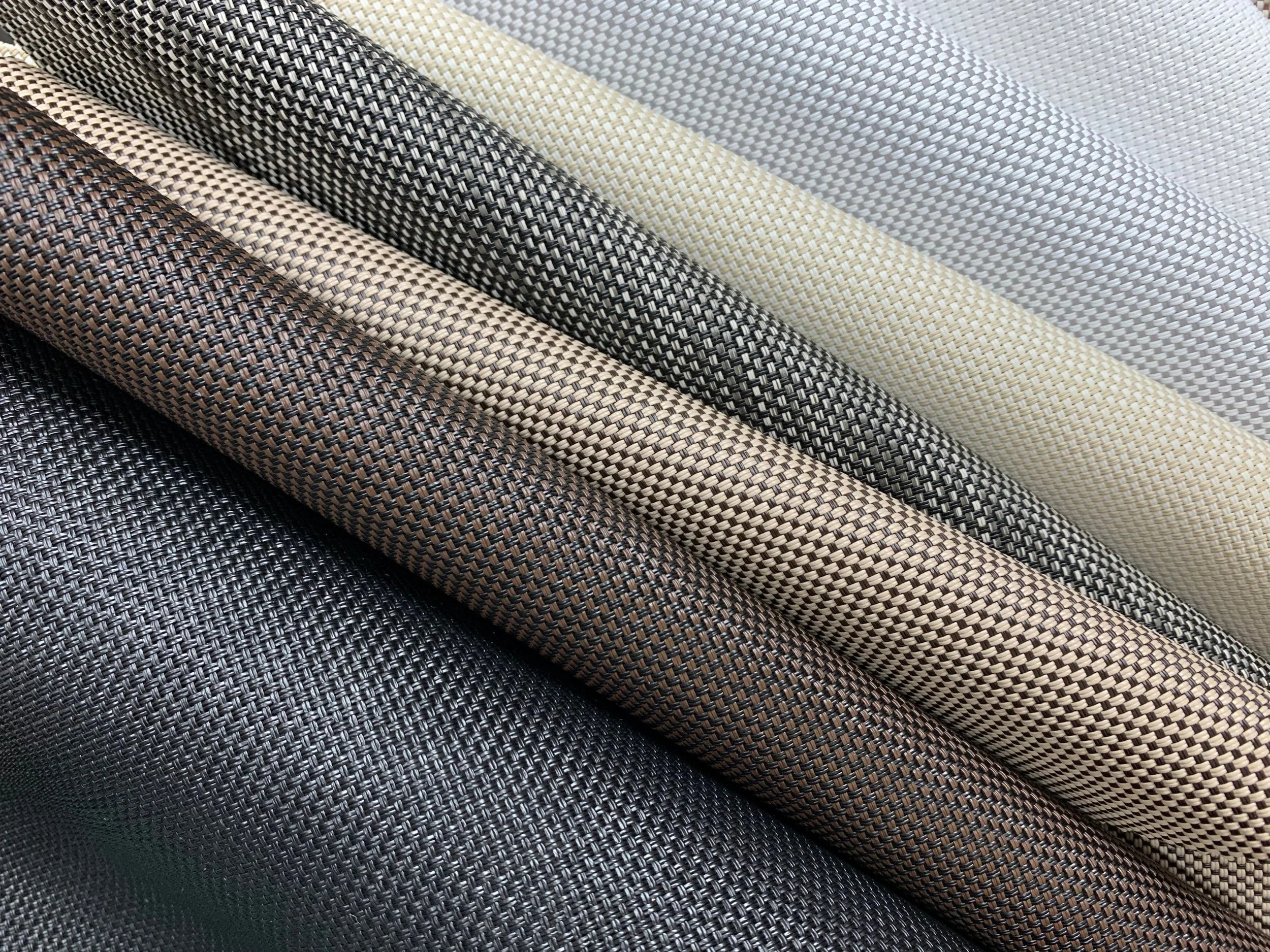 Close-up of fabric rolls with woven textures in shades of black, brown, beige, and white.