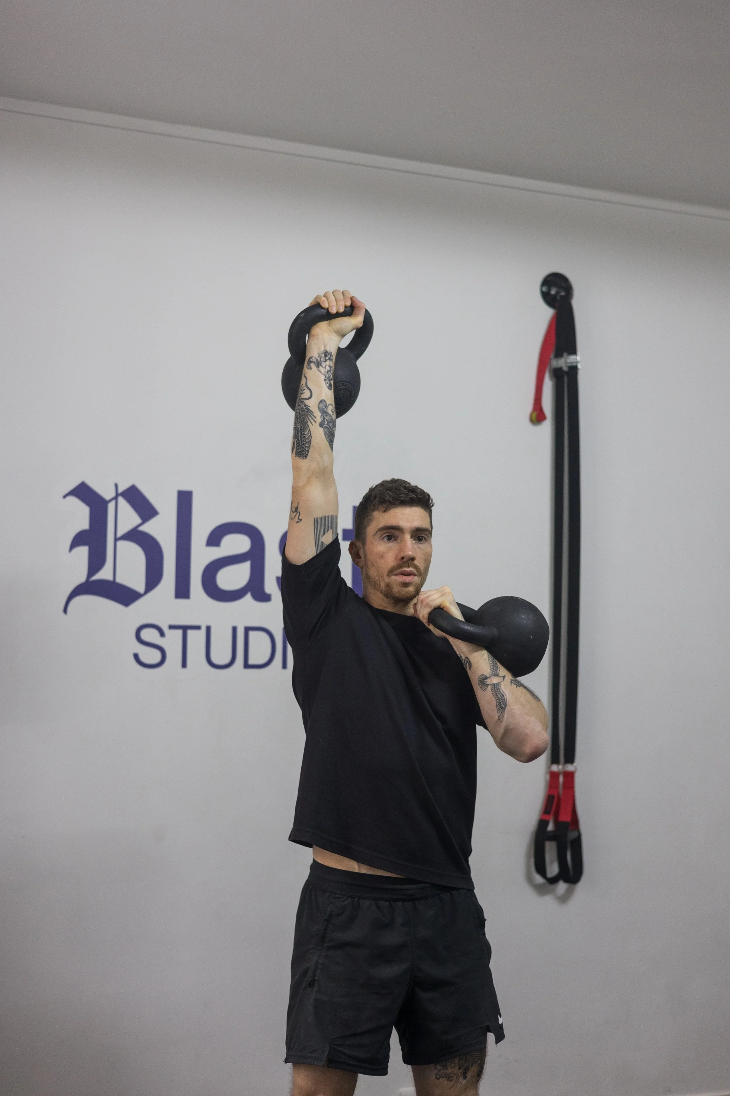 Un homme soulevant un kettlebell dans une salle d'entraînement.