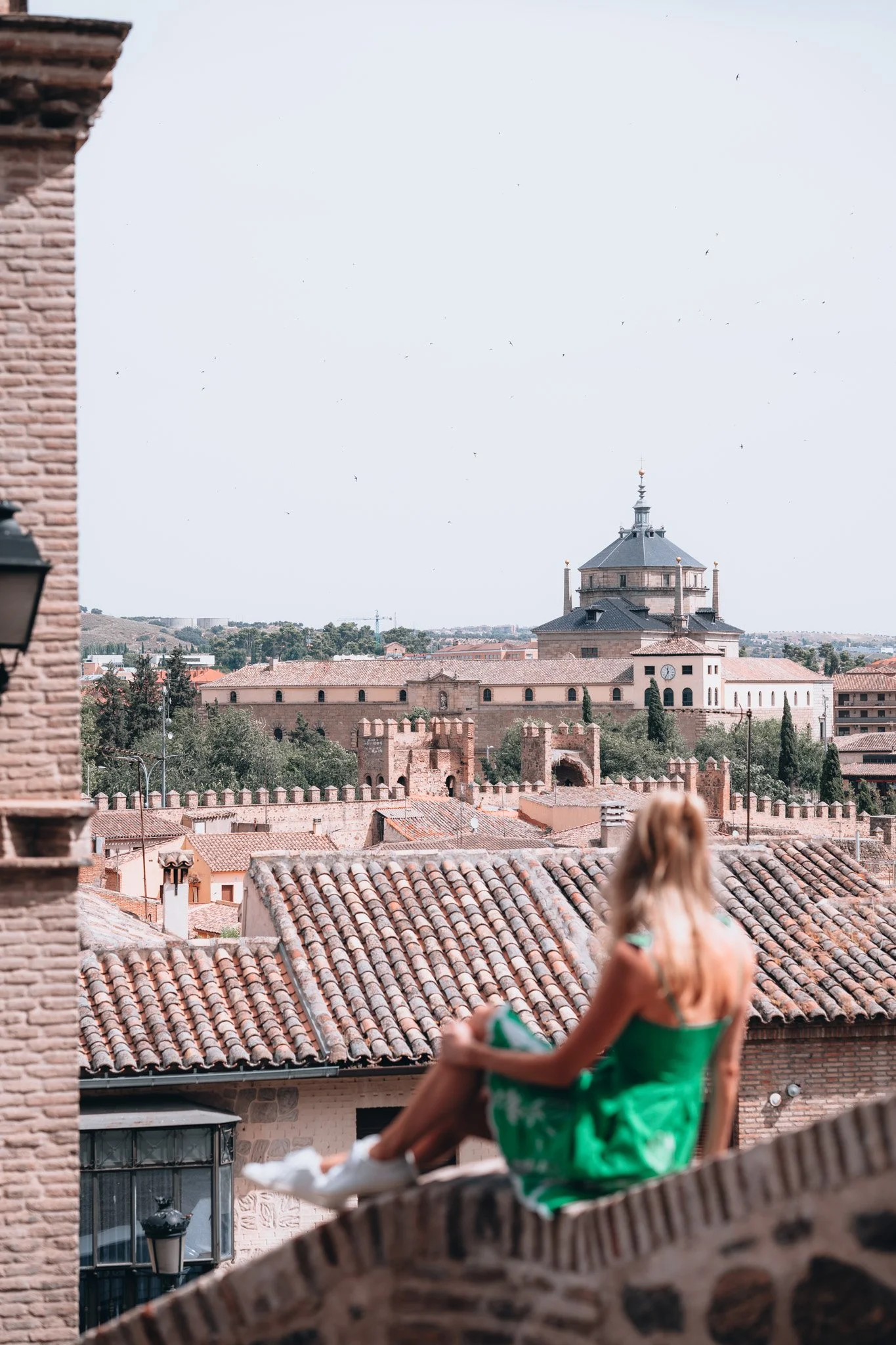 Traveler overlooking a historic cityscape in Spain.