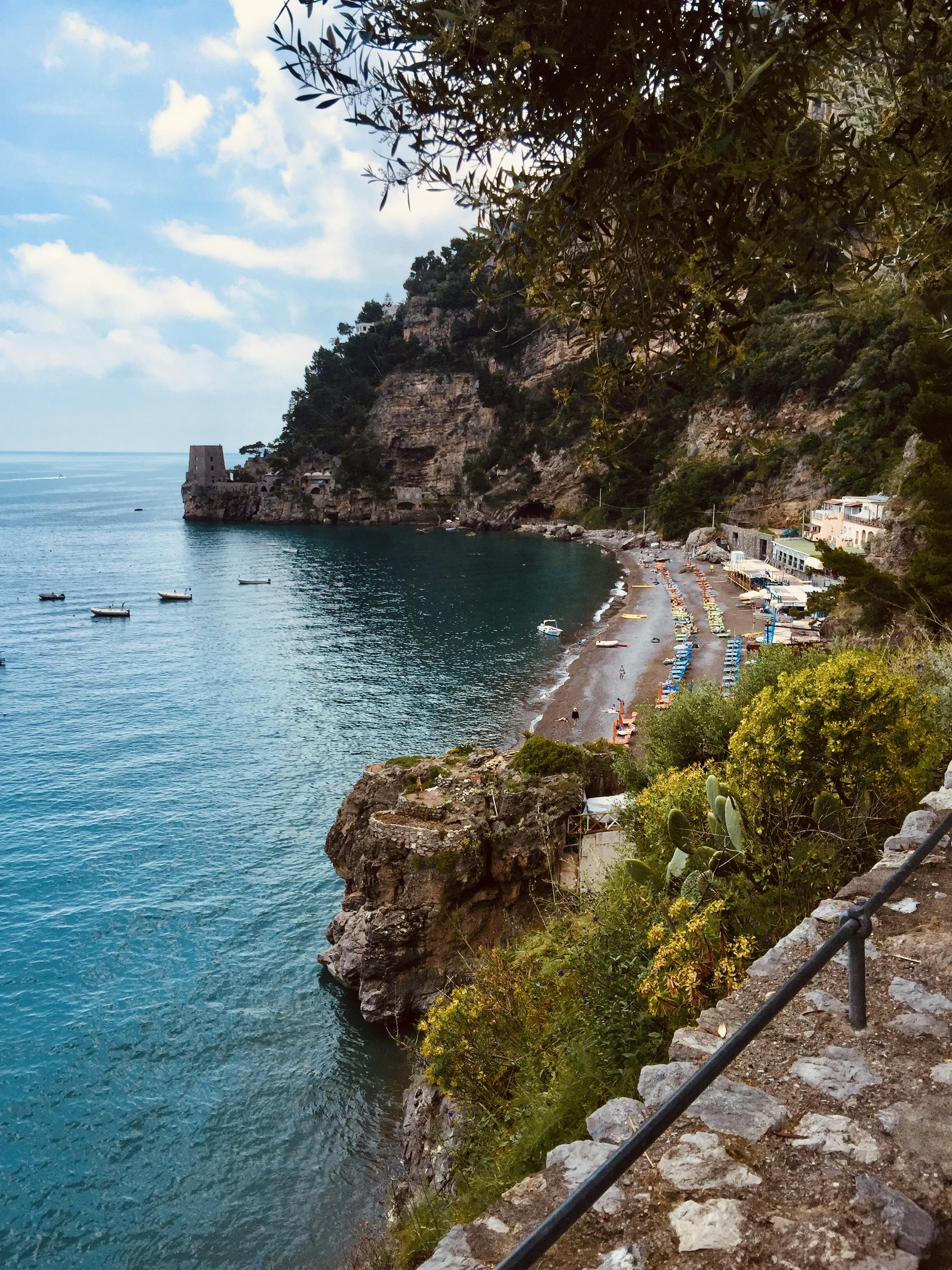 Mediterranean coastline with a turquoise sea, rocky cliffs and a beach along the Amalfi Coast, Italy.