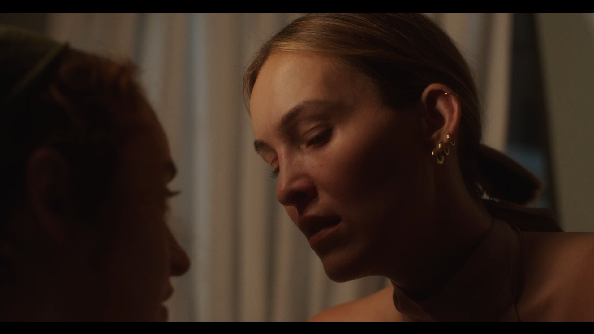 Close-up of two women touching foreheads and smiling in an intimate moment