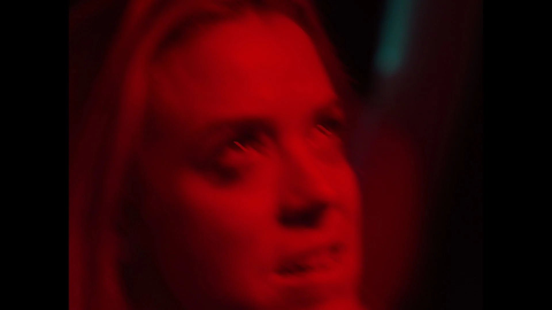 Blurred red-tinted photo of a person's face with vibrant hues and motion effects.