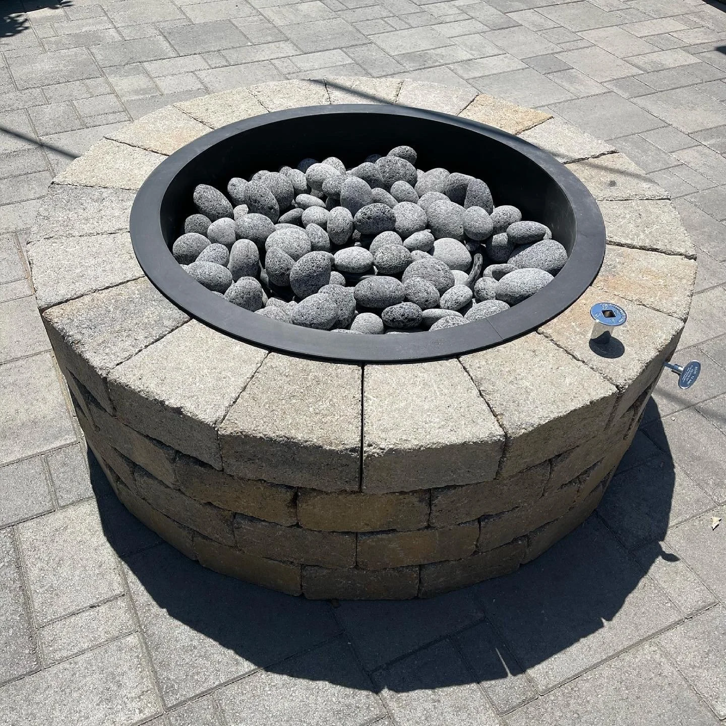 Custom fire pit kit installation integrated into the paver patio for a clean, finished outdoor living feature. S'mores time!