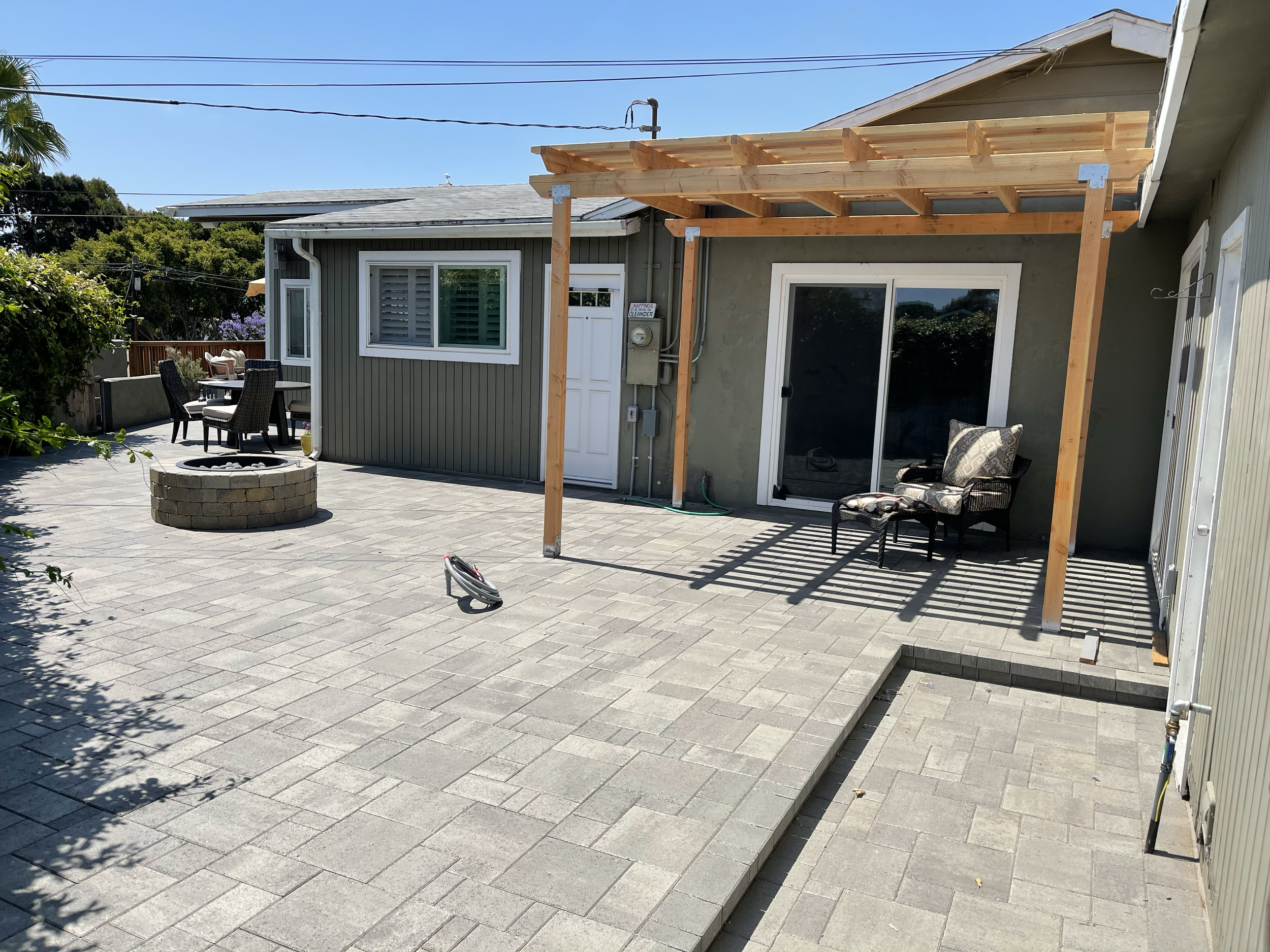 Paver patio with custom steps, pergola, fire pit kit, and gas line installation for a complete outdoor hang out area.