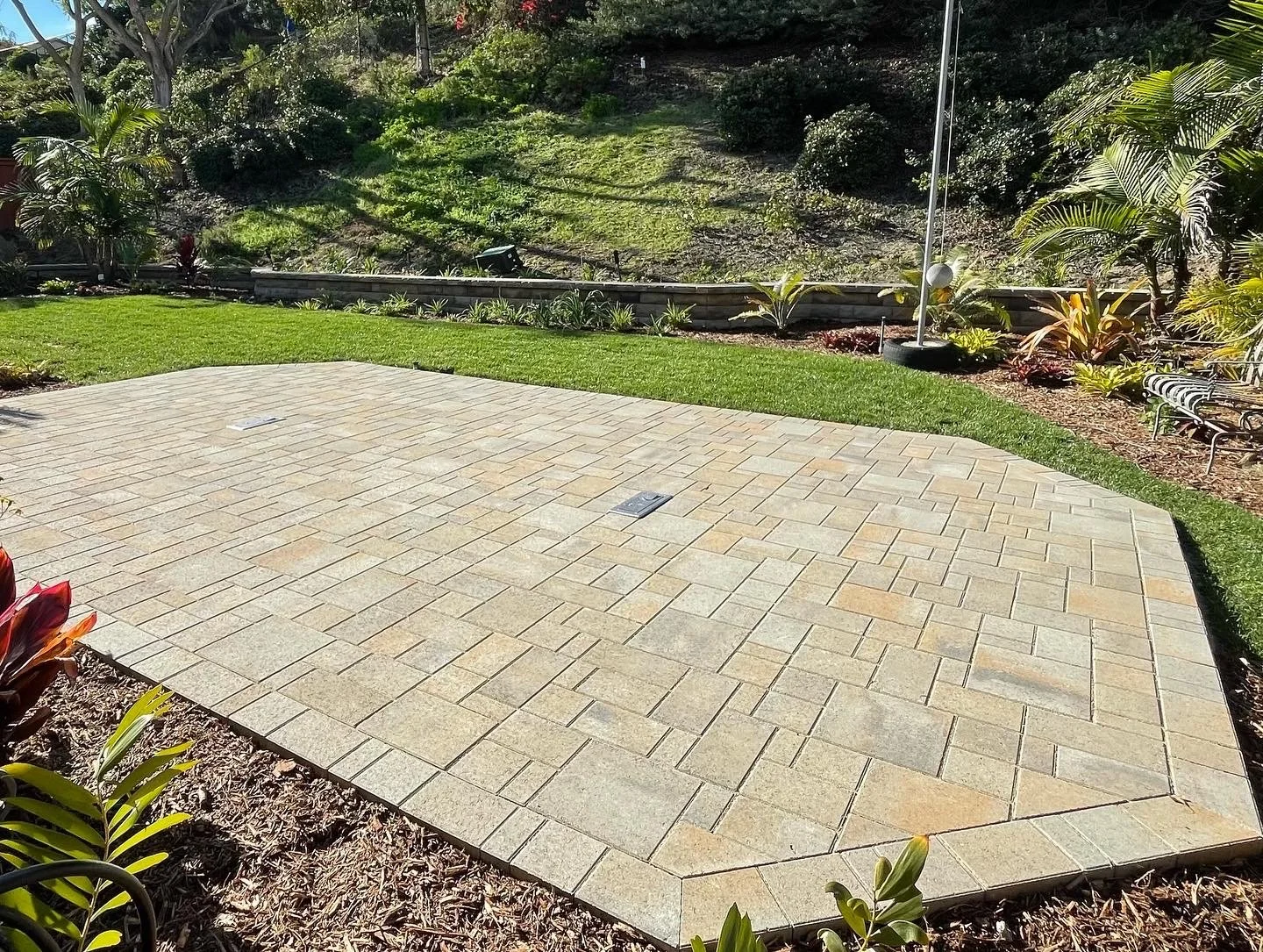 Full landscape design including paver patio, fresh sod , plants , and a stack retaining wall in Carlsbad CA