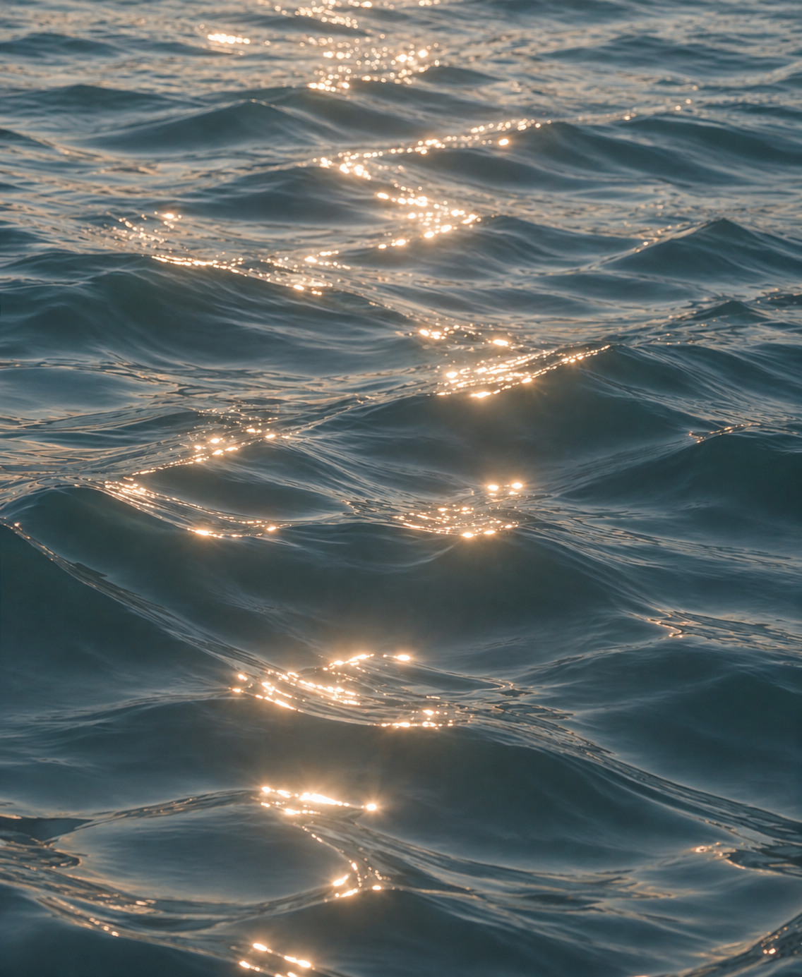 Sunlight reflecting on the surface of ocean water with gentle waves.