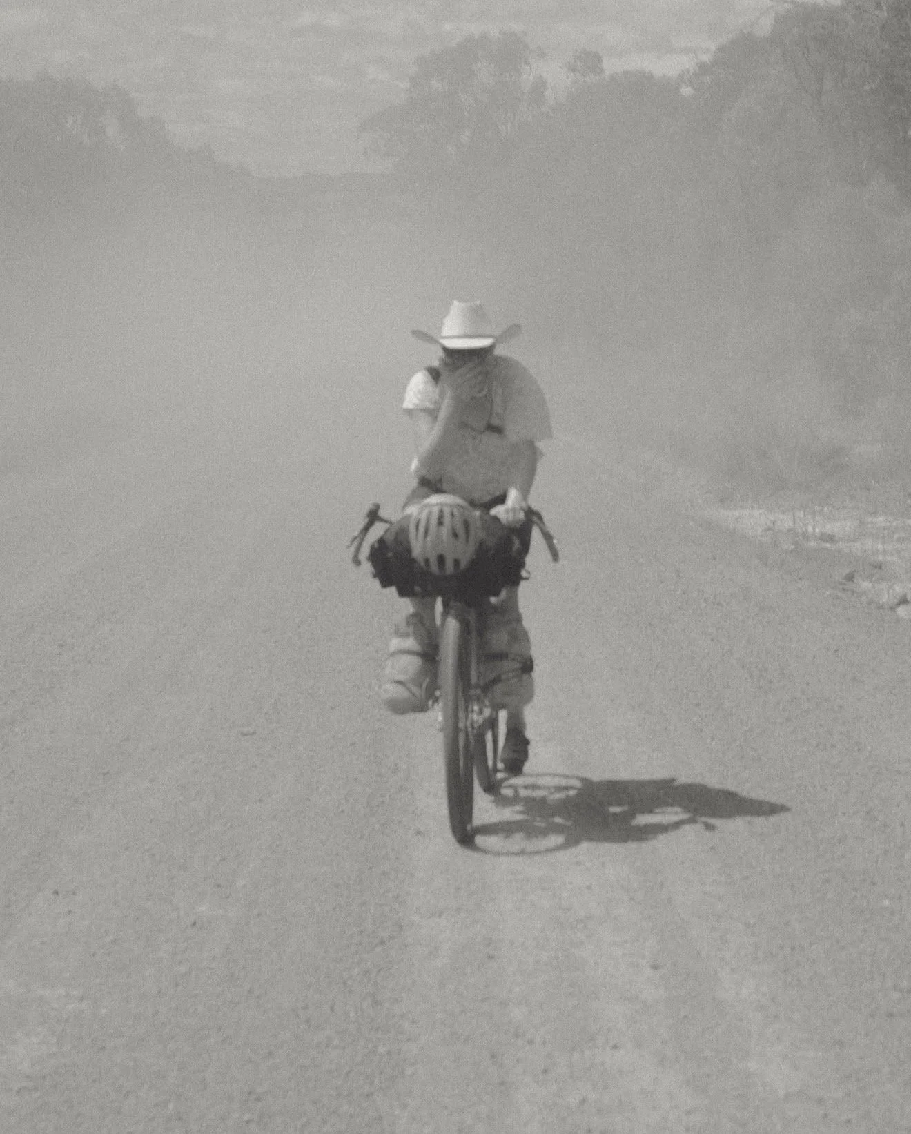 Gravel bike rider covering mouth