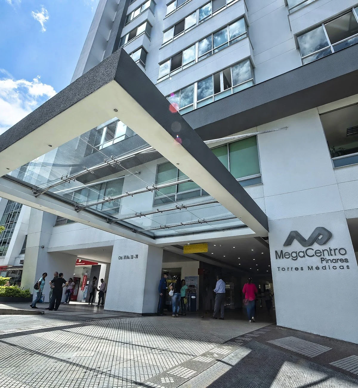 People entering and exiting the MegaCentro shopping mall in Torre Médicas, Pinares, on a sunny day with clear skies