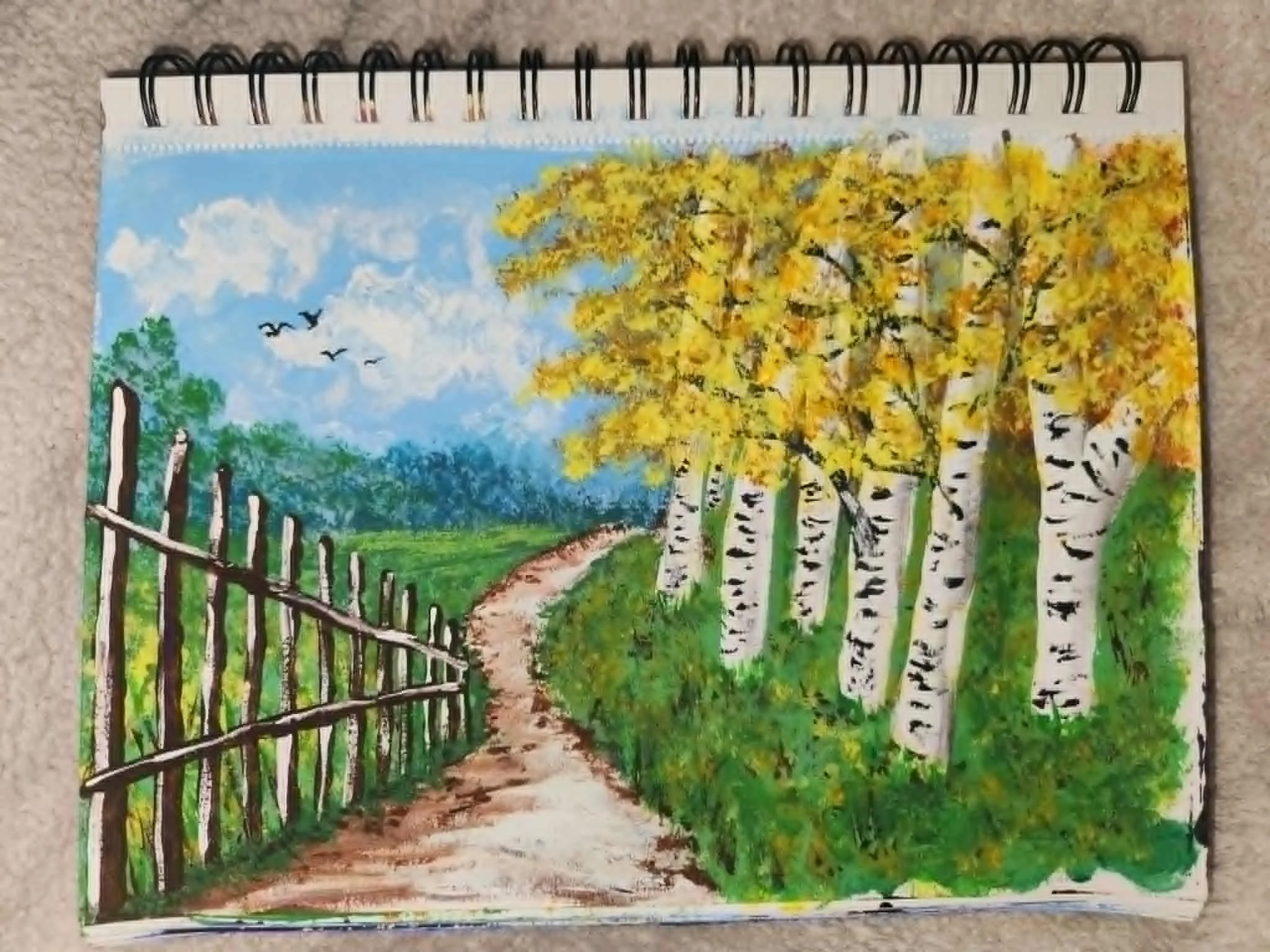 Original painting. A painted landscape scene depicting a dirt pathway through green grass, surrounded by a white picket fence and tall trees with yellow leaves, under a blue sky with scattered clouds and flying birds.
