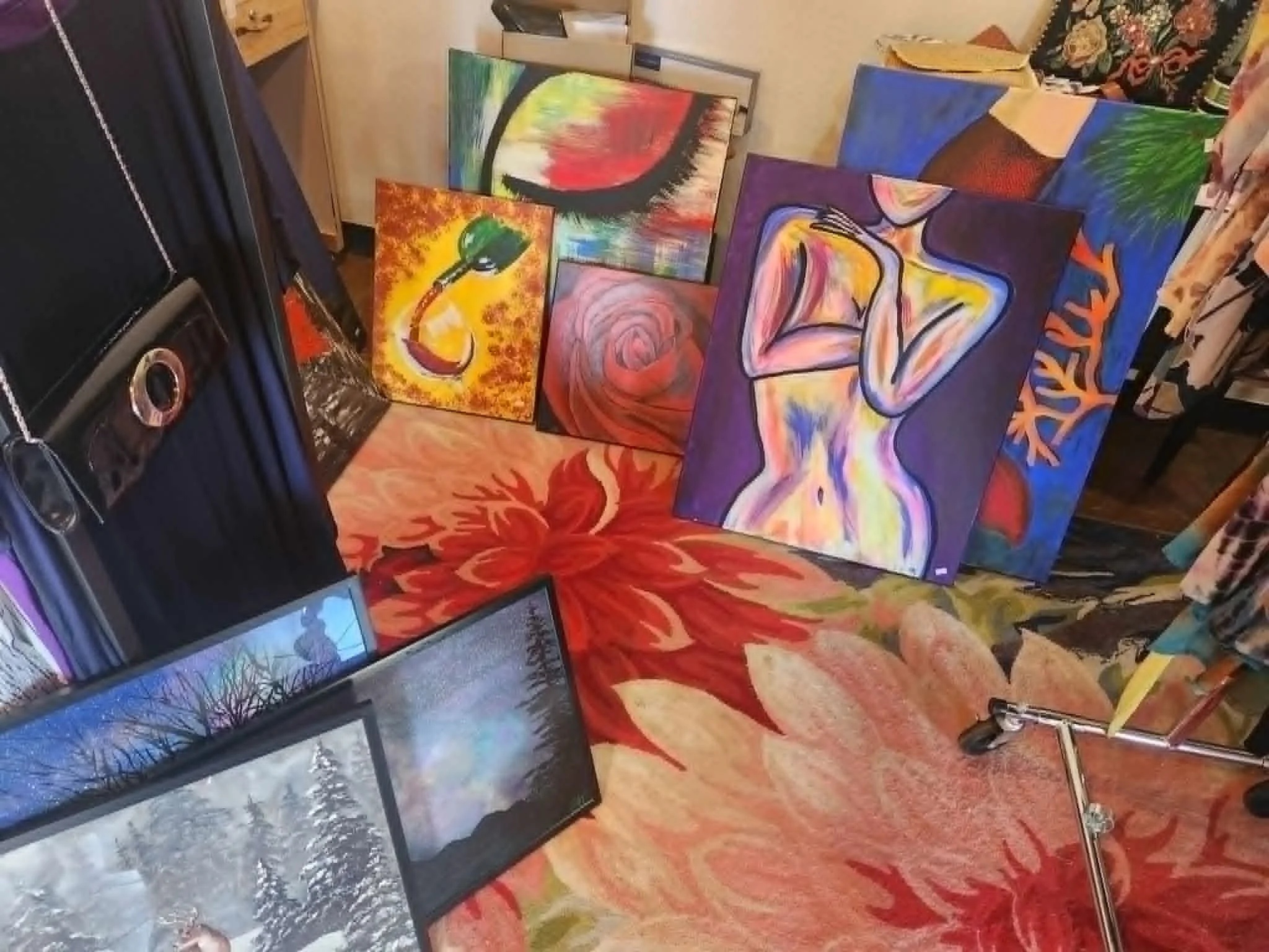 Original painting. Colorful abstract paintings displayed on tables at an art exhibit or sale.