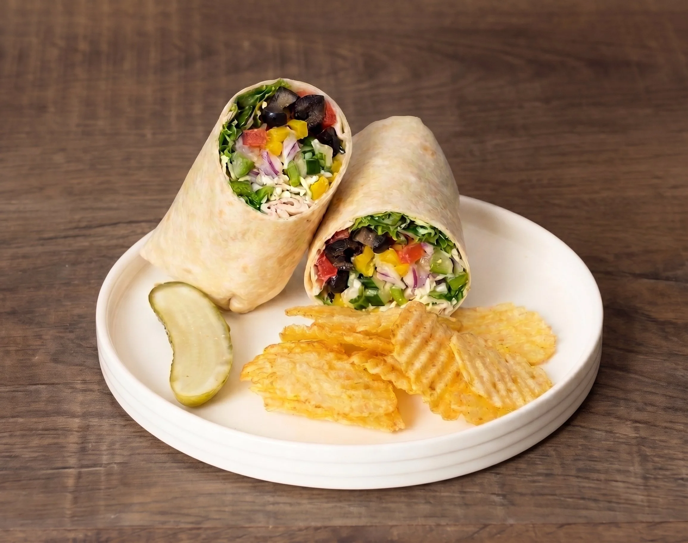 Veggie Wrap with fresh vegetables, chips, and pickle