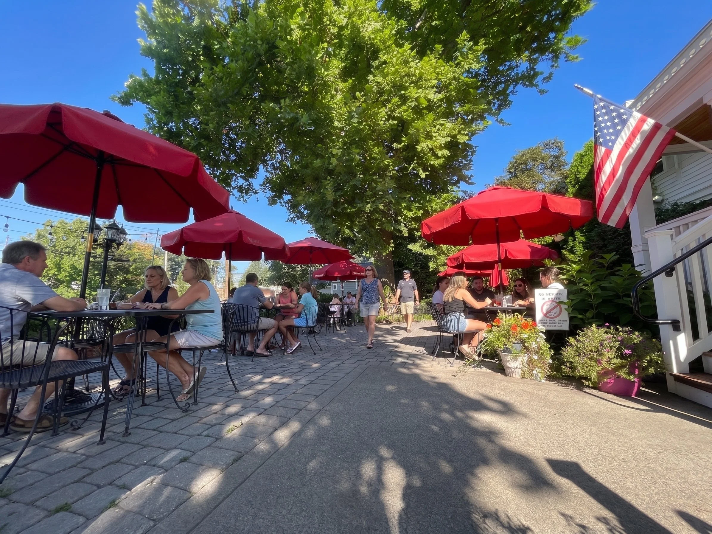 ROKA outdoor patio with red umbrellas and shaded seating