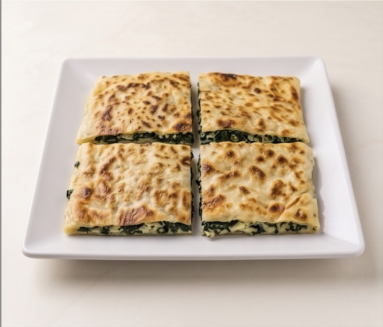 Savory stuffed flatbread with herbs, cut into four pieces