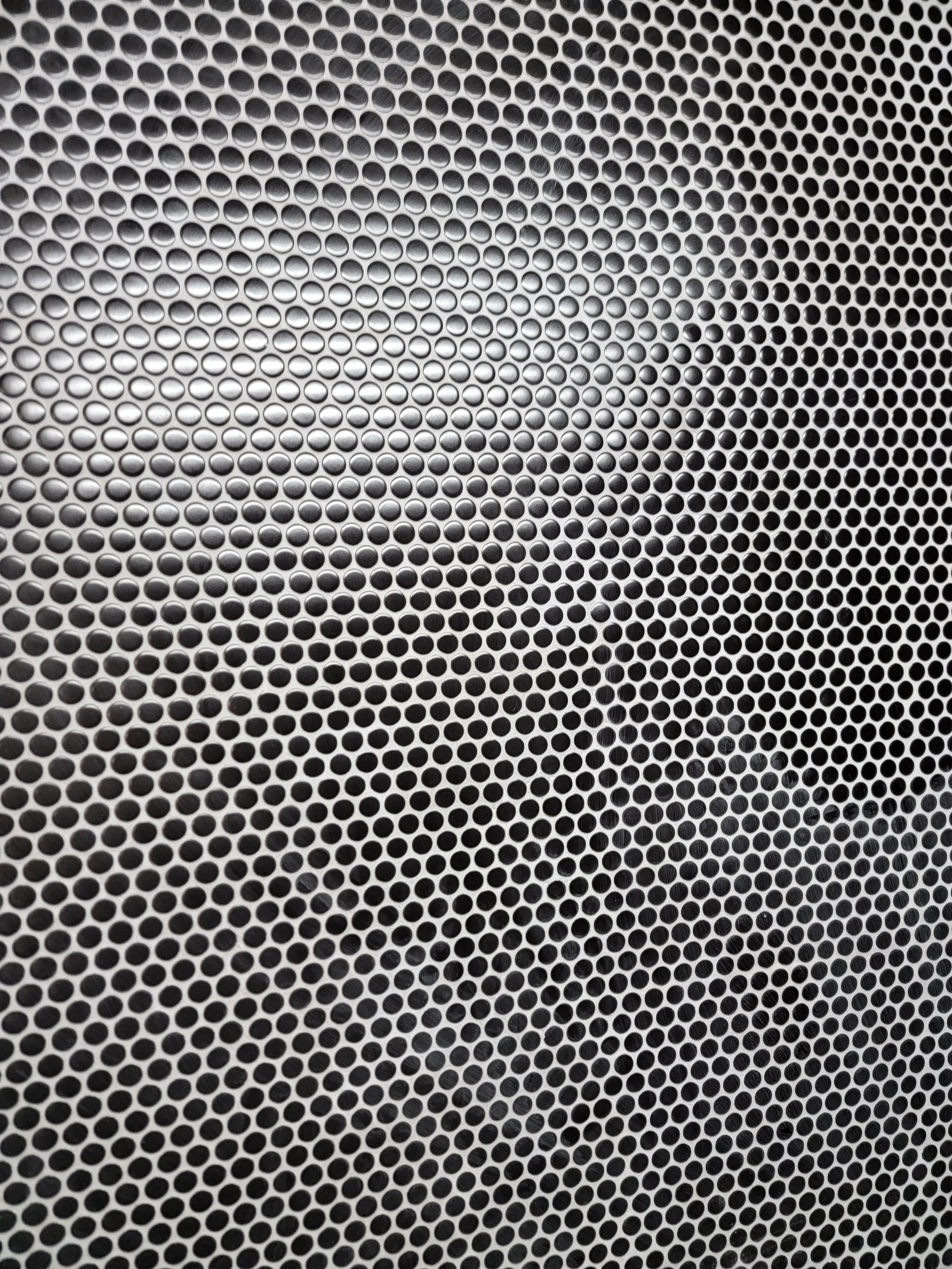 Close-up of a wall tiled with black penny tile.