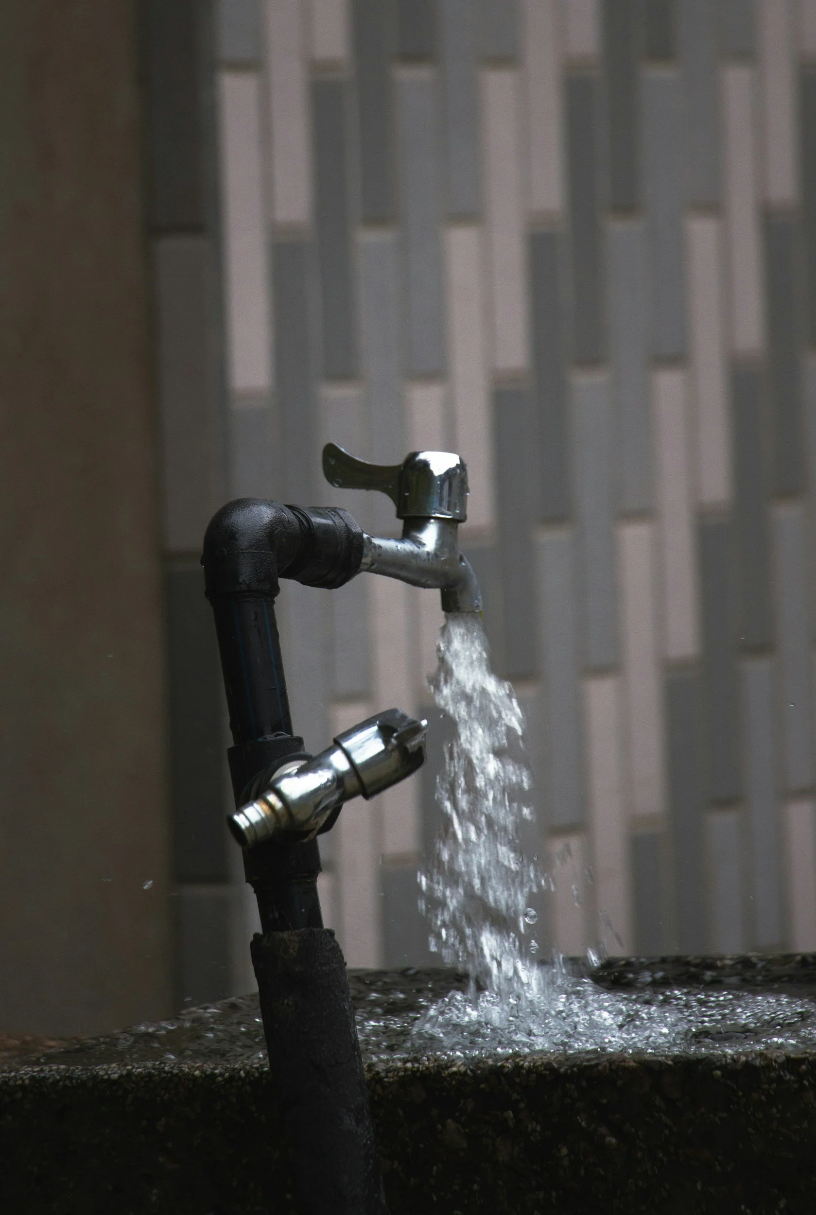 Burst water pipe requiring emergency plumbing repair.