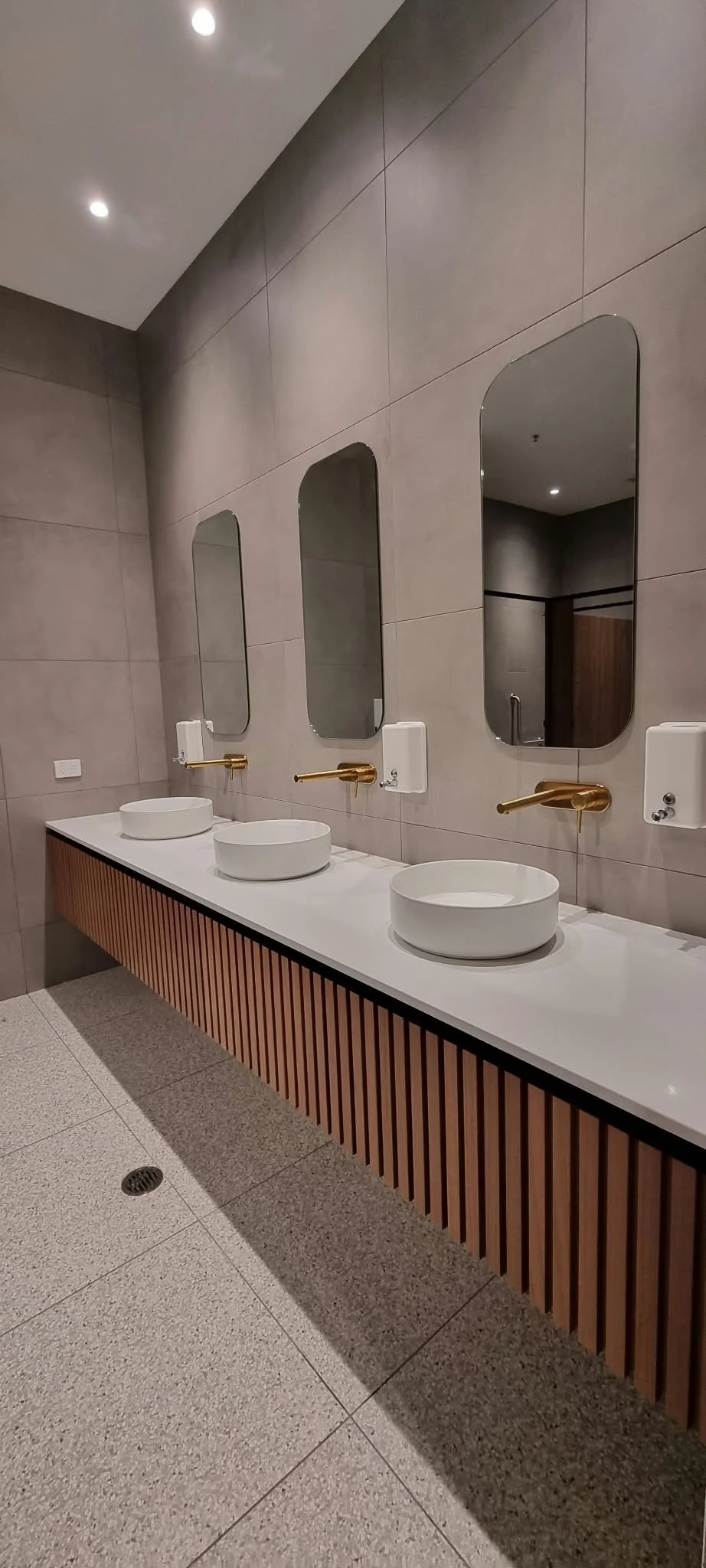 Commercial bathroom plumbing fit-out with three basins and wall-mounted tapware.