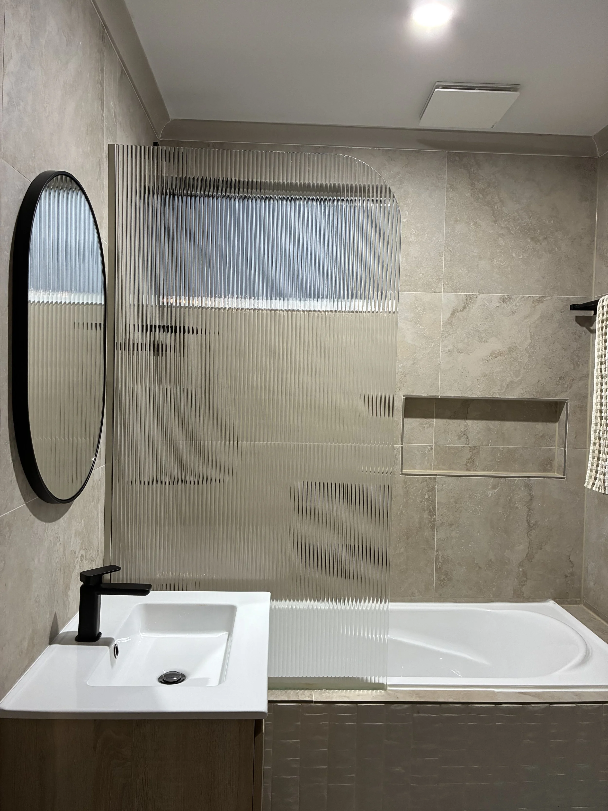 Modern bathroom plumbing fit-out with bath, basin and tapware.