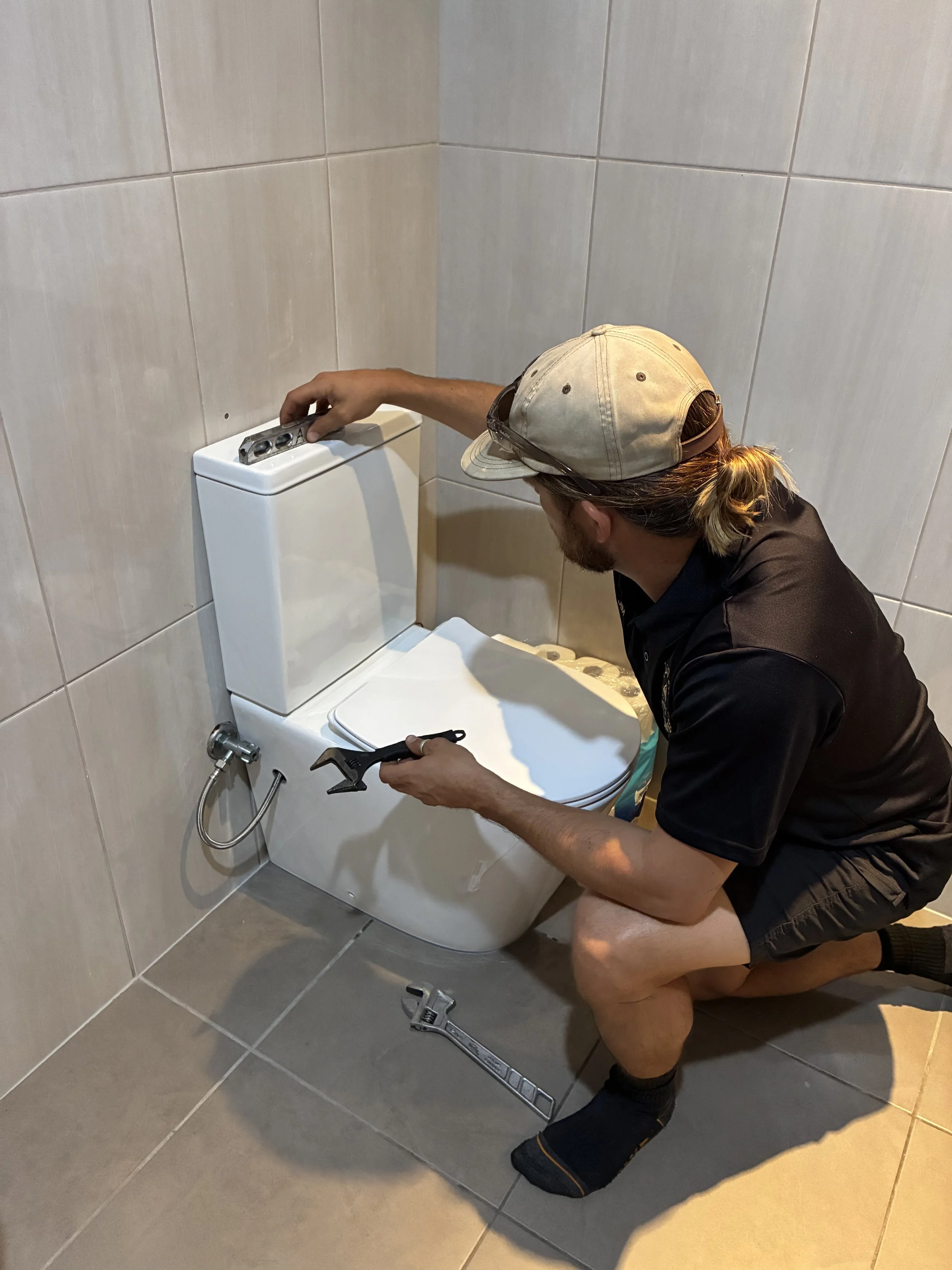 Jim from Crums Plumbs carrying out a toilet plumbing repair.