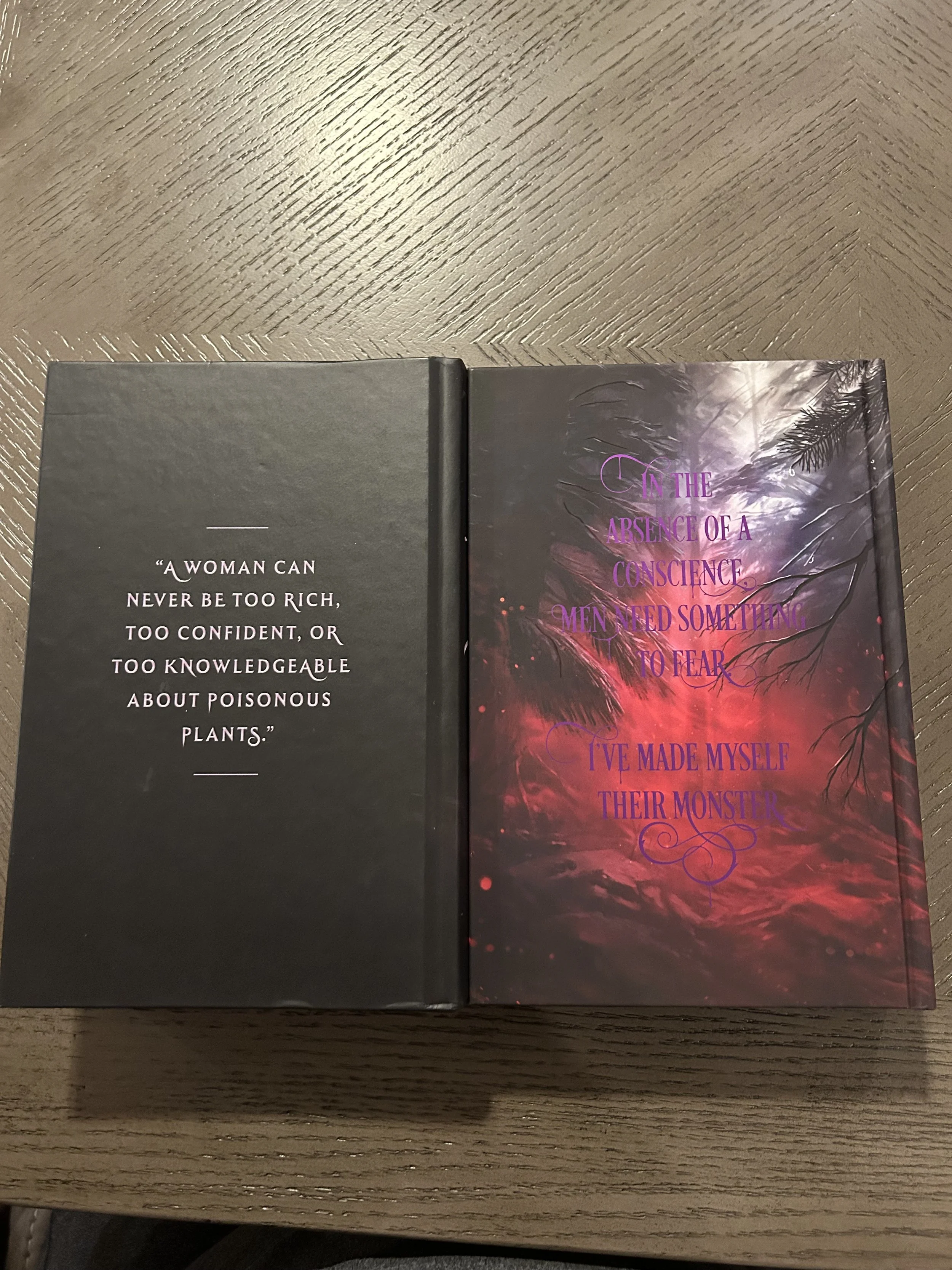 The backs of two case-bound editions of The Poison Daughter side by side: The retail hardcover with a quote about poisonous plants, and the Coveted Cover edition with red-and-black artwork and a quote about becoming a monster.