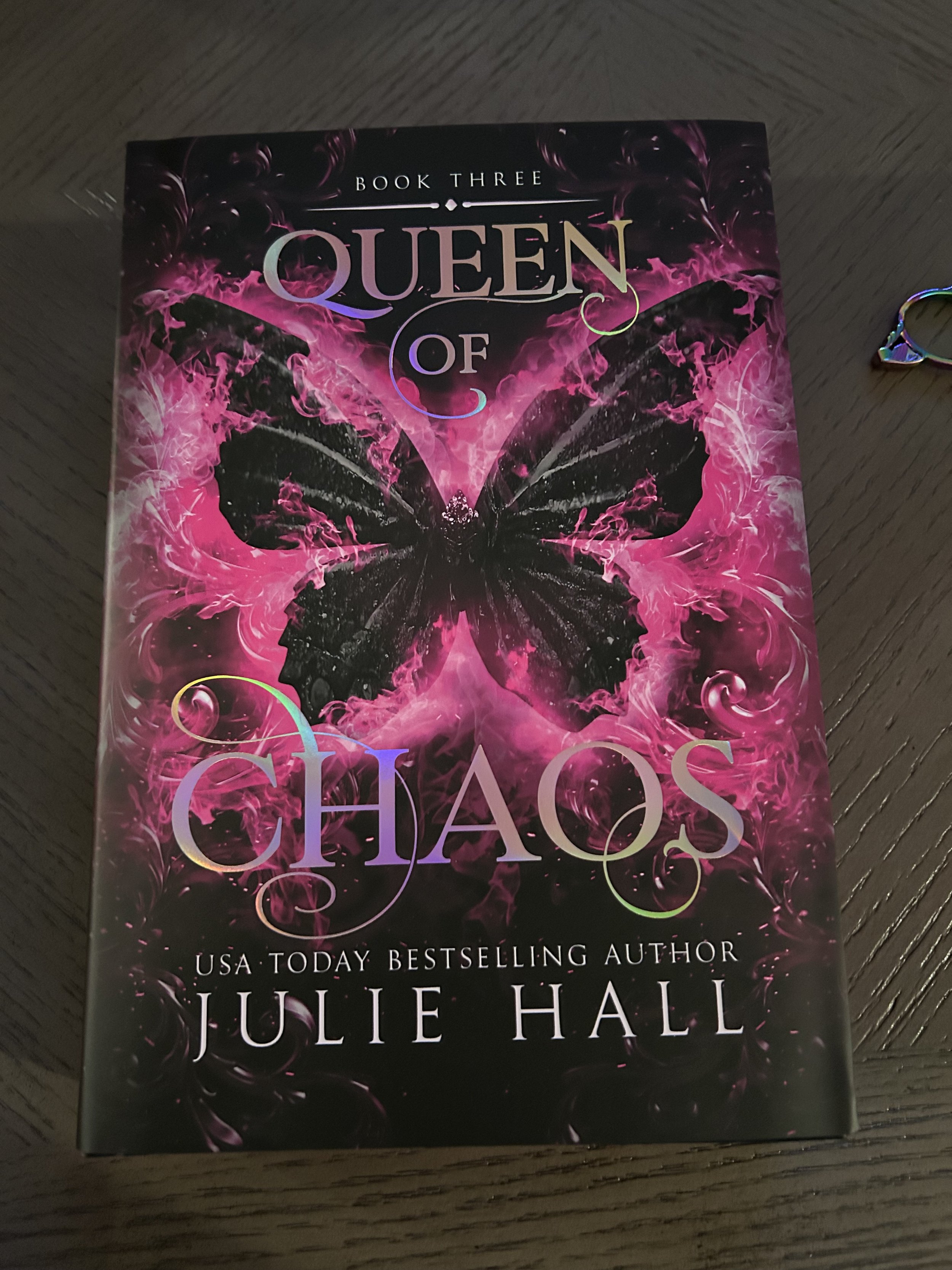 Queen of Chaos by Julie Hall special-edition dust jacket featuring a large black butterfly surrounded by vivid pink artwork.