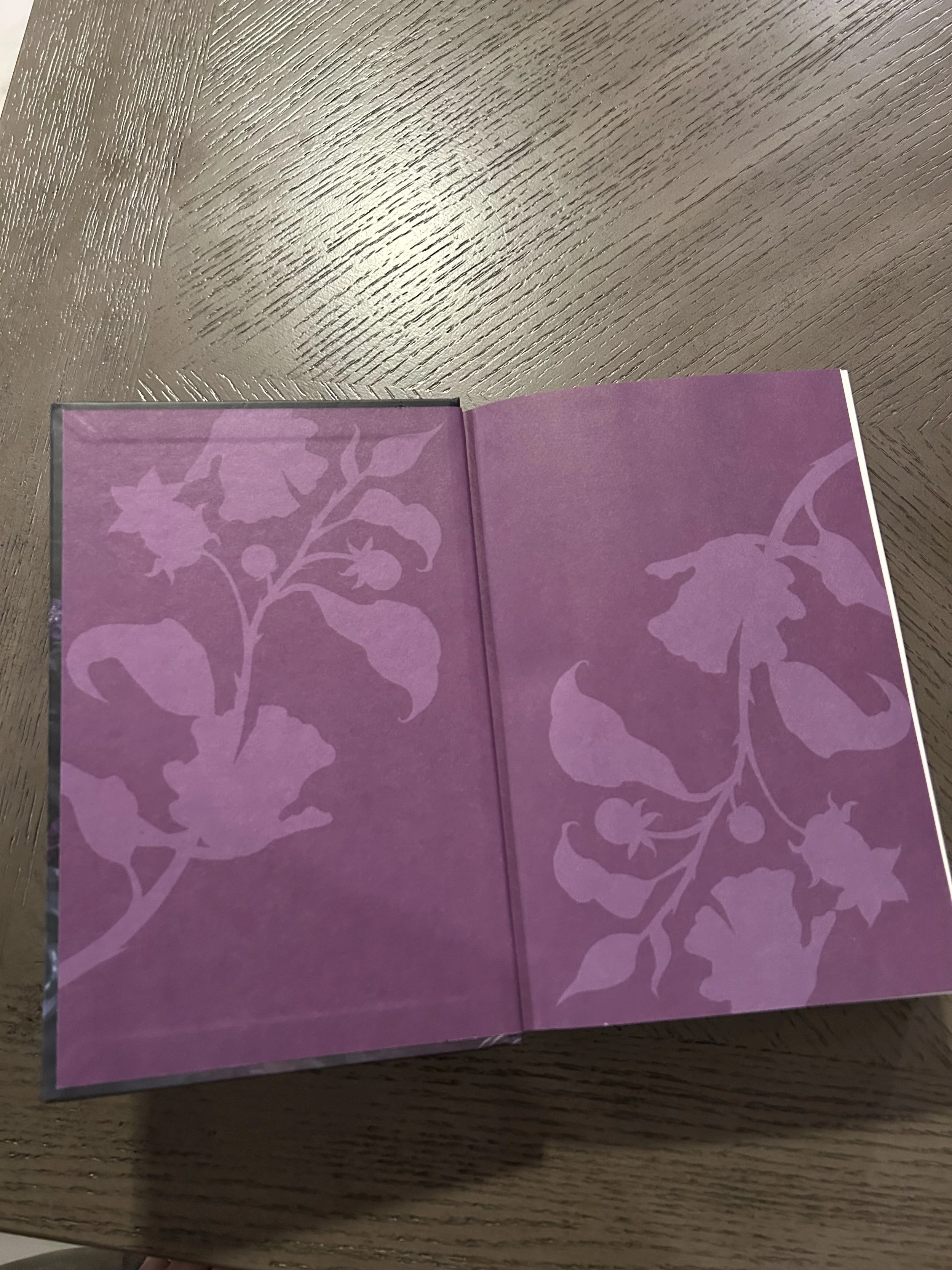 Lavender endpapers decorated with pale silhouettes of poisonous flowers, leaves and berries.